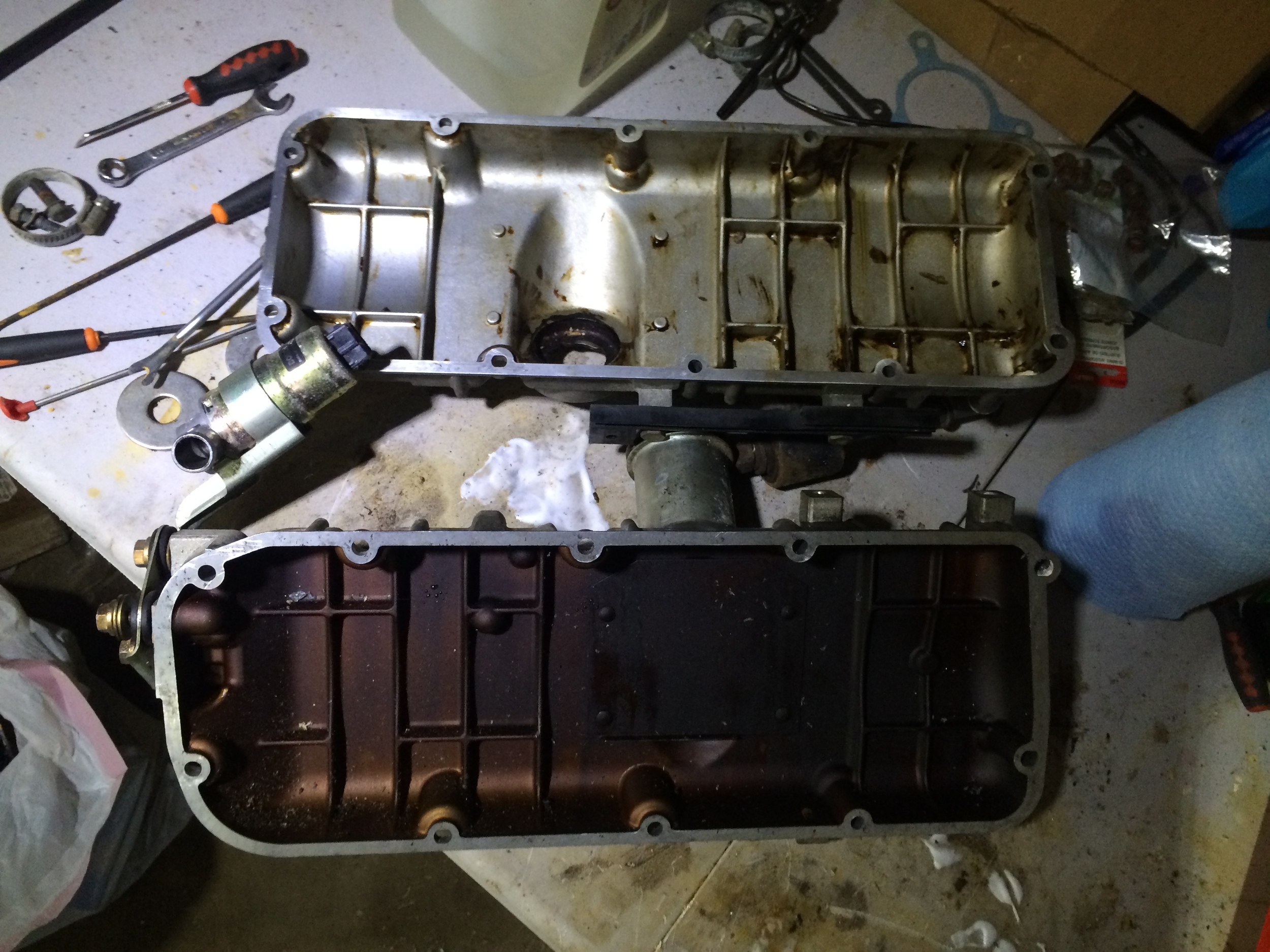 A cleaned gasket cover next to a dirty cover.