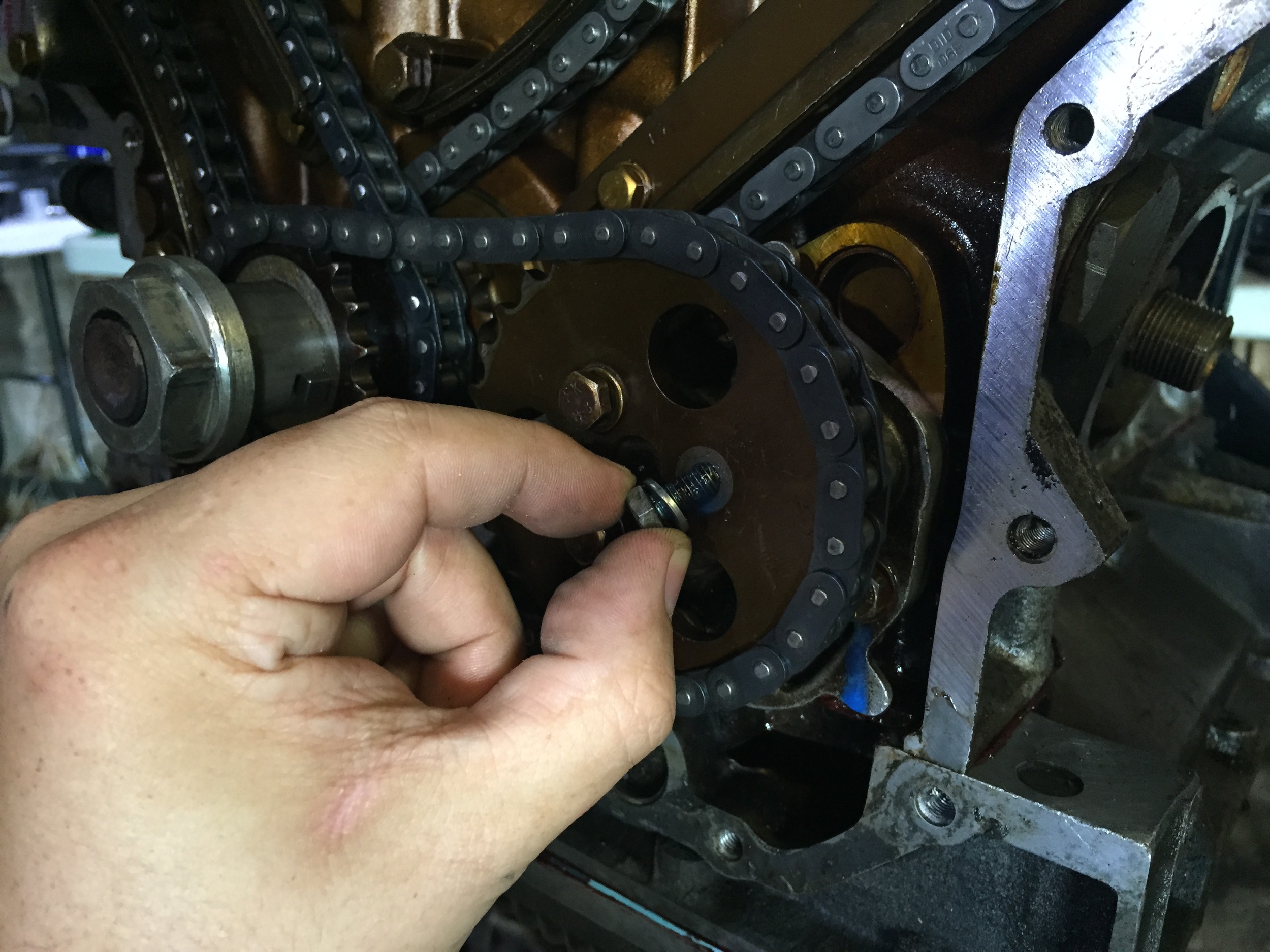 Inserting a sprocket bolt after applying blue LockTite.