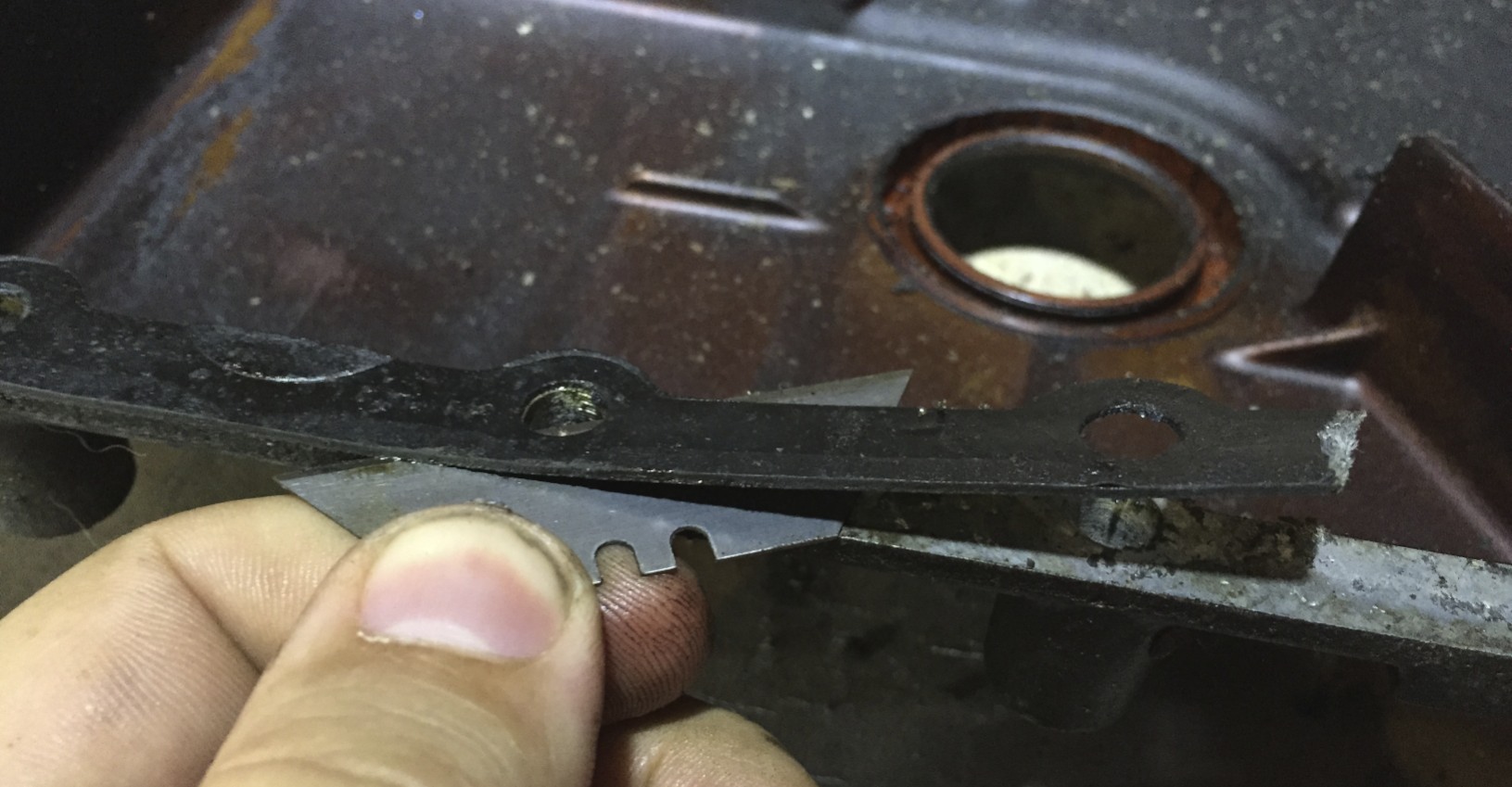 Using a razor to separate the gasket from the aluminum.