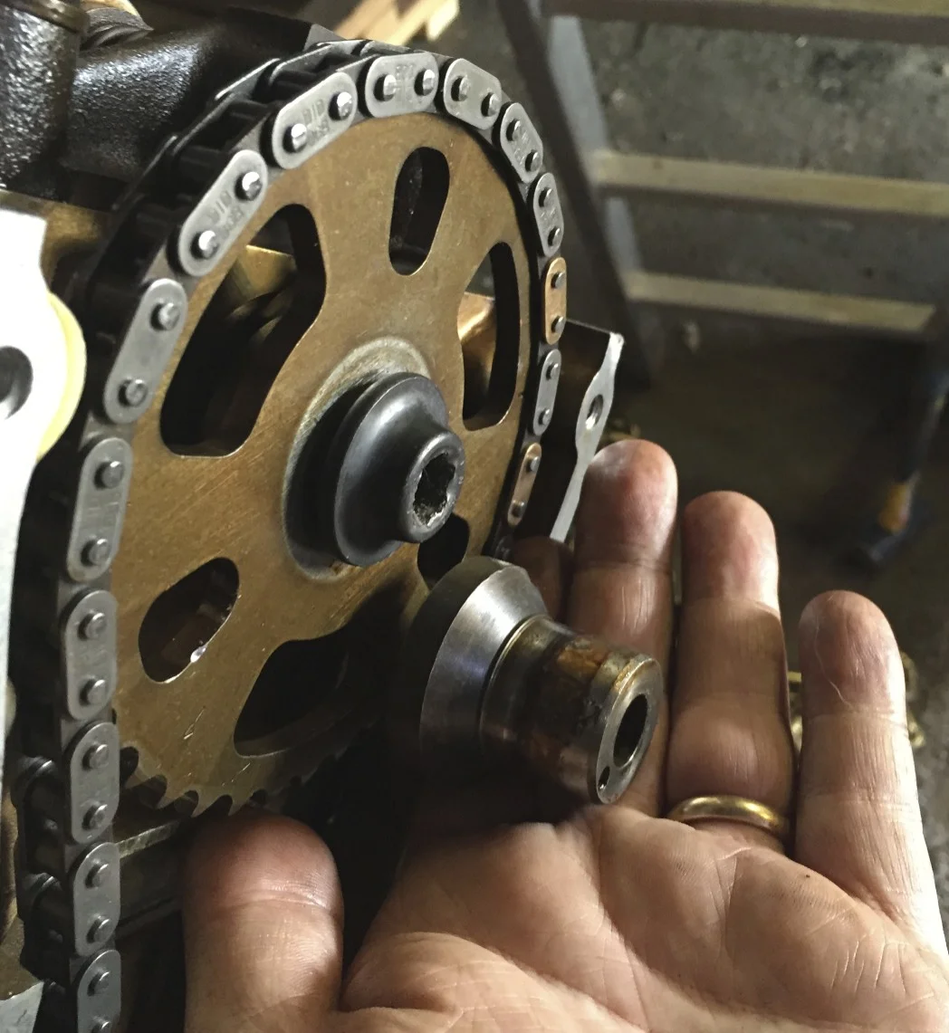 A 2.8L bolt installed on the 3.0L sprocket. I'm holding the spacer that the 3.0L engine originally used (along with a longer bolt, not shown) that would have been used to attach to the distributor.