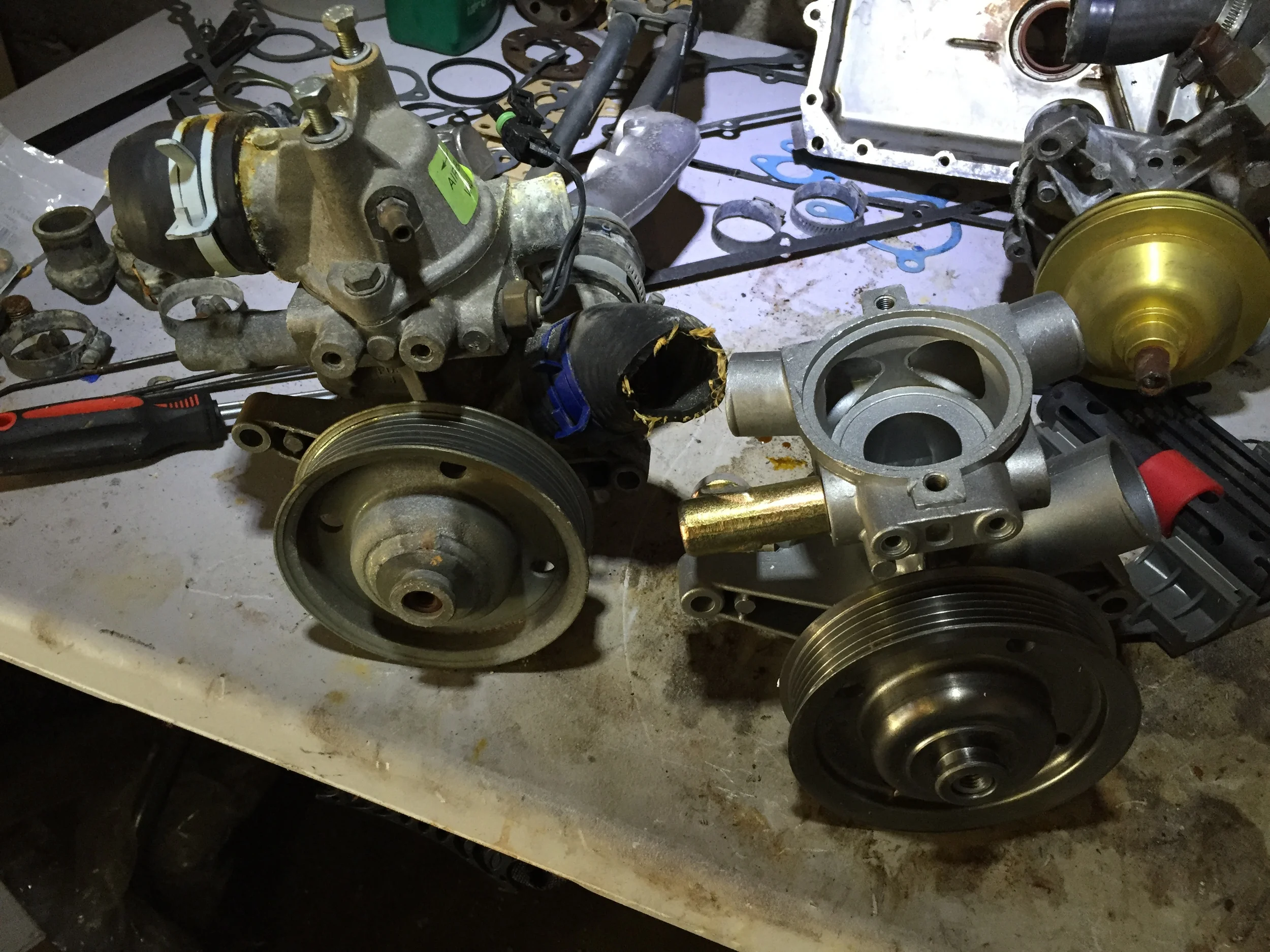 The old 3.0L pump (left) and the new one (right); the 2.8L pump is visible in the background.