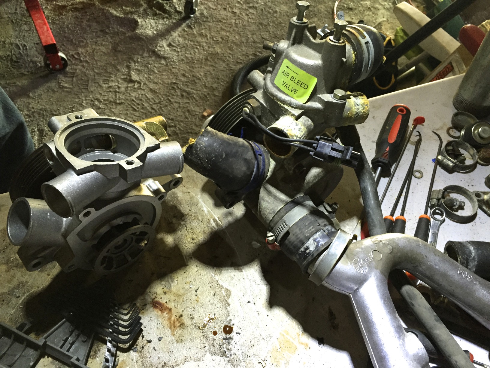 The new pump (left) and the old one (right). Clearly the thermostat housing and rear housing need to be reused from the old pump..