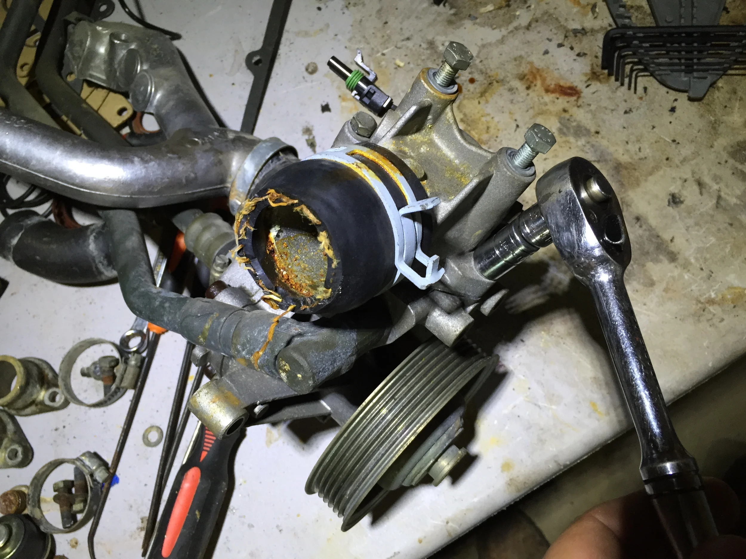 Removing the bolts for the thermostat housing with an 11mm socket.