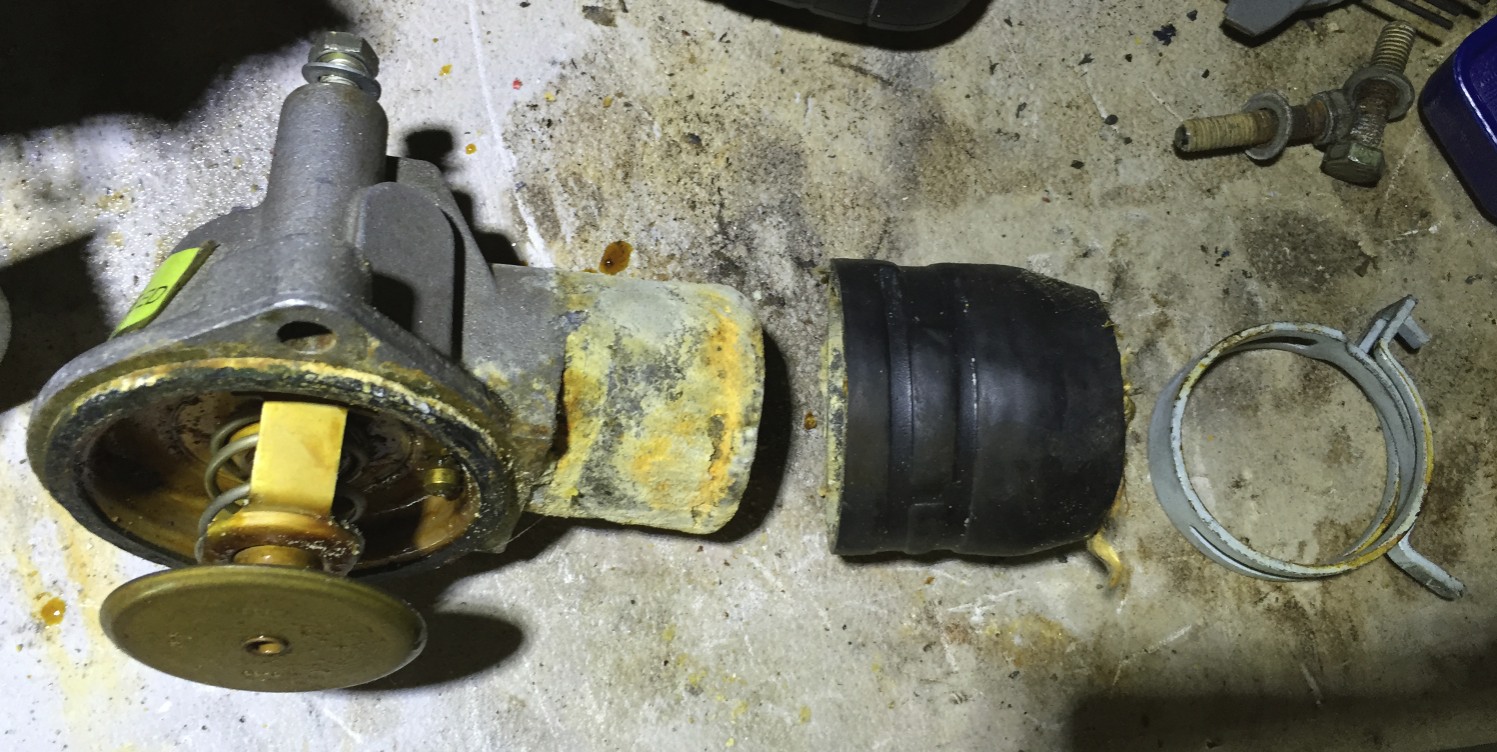The thermostat housing (left< the old hose (middle) and the spring hose clamp (right).