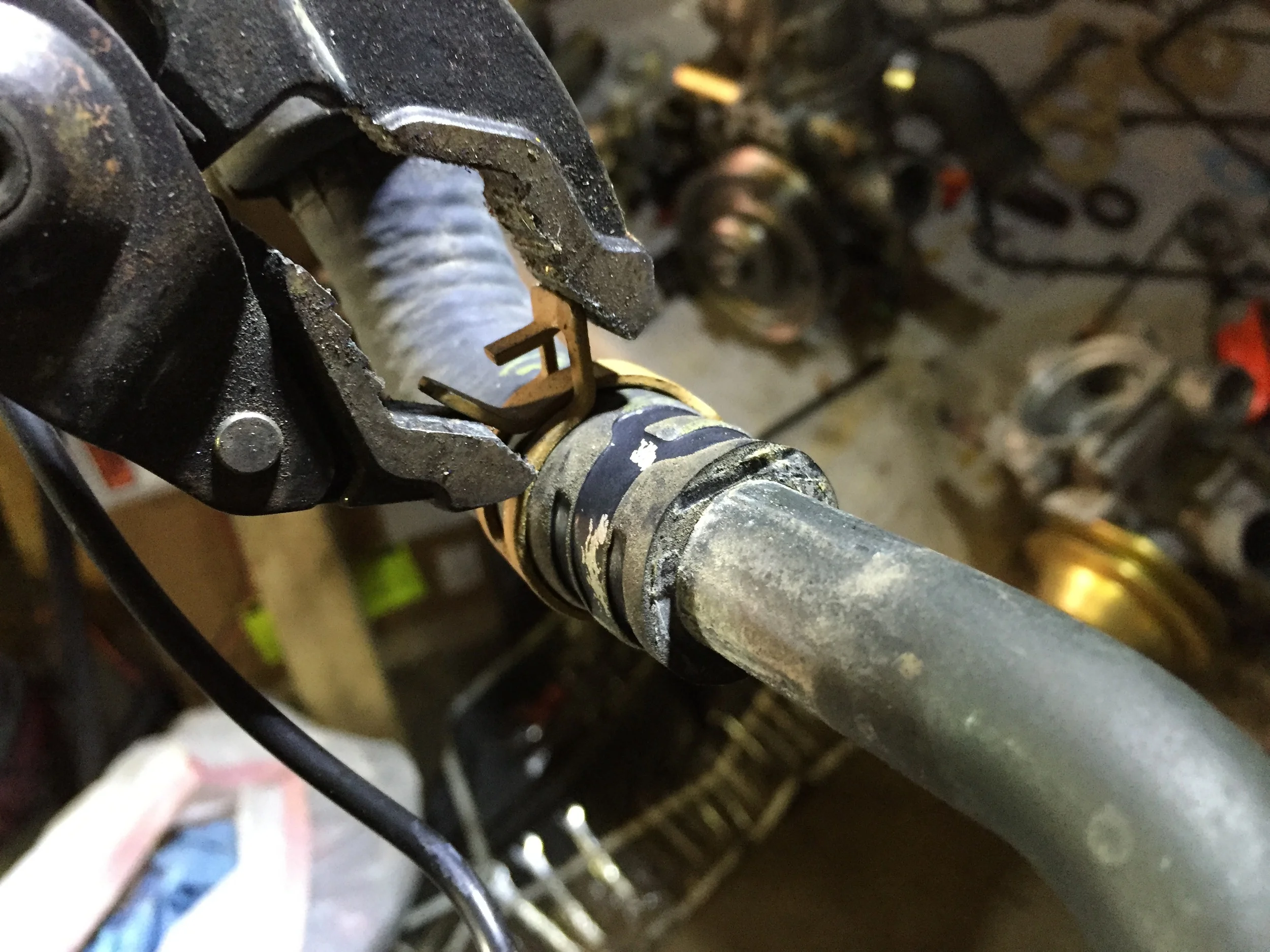 Using adjustable pliers to open a spring hose clamp.
