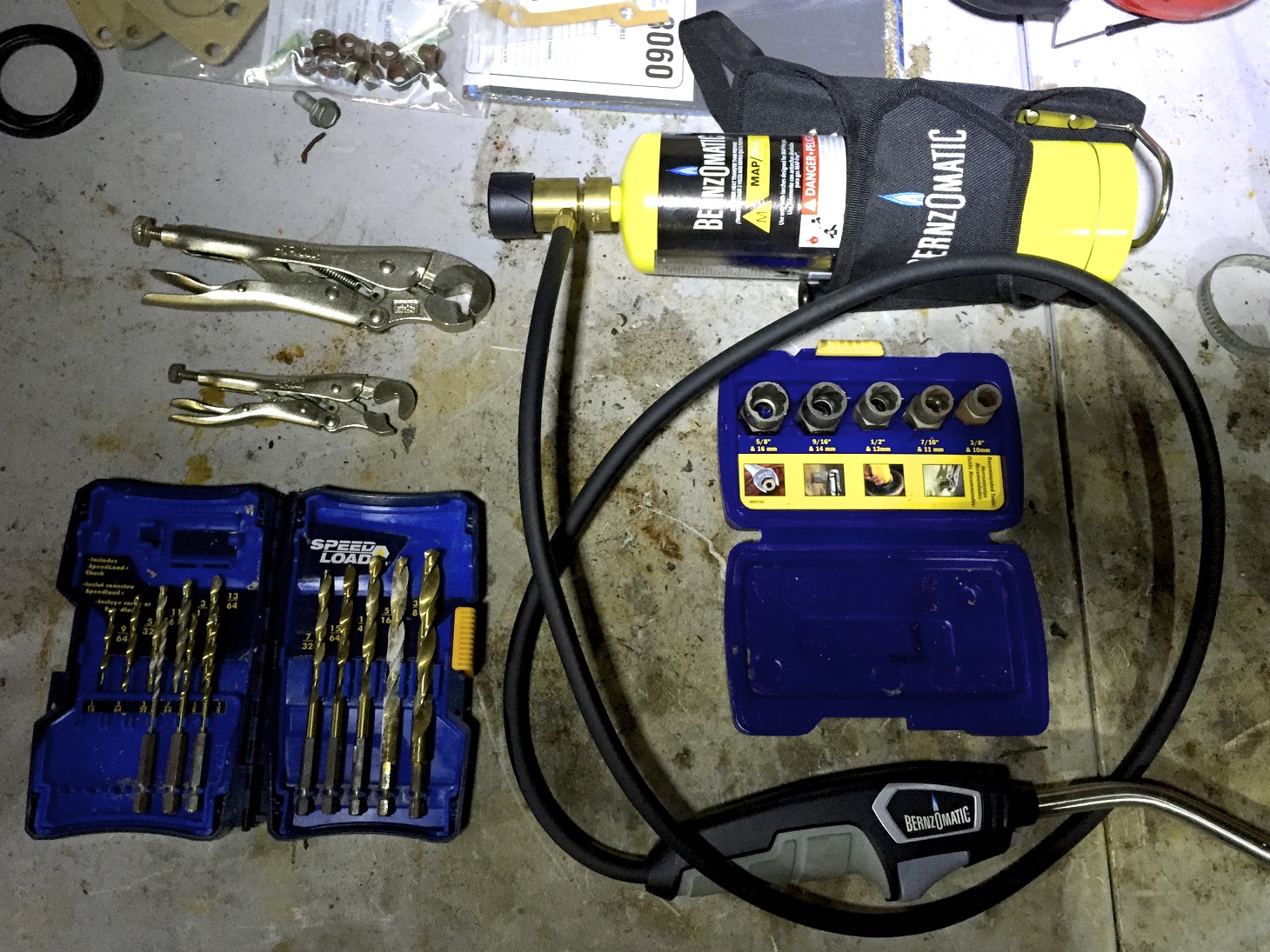 Some bolt removal tools: bolt vice grips (top left), drill bits (bottom left), a MAP torch (top right), and bolt grip extractors (middle right)