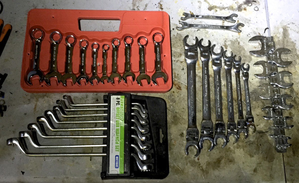 Various specialty wrenches: stubby (top left), offset (bottom left), ratcheting open ended (top right), tilt-head (middle right), and crows feet (right).