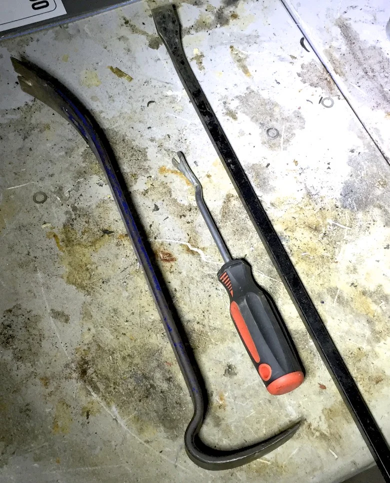 A home improvement style pry bar (left), a small foot pry bar (middle) and a long-handled pry bar (right).