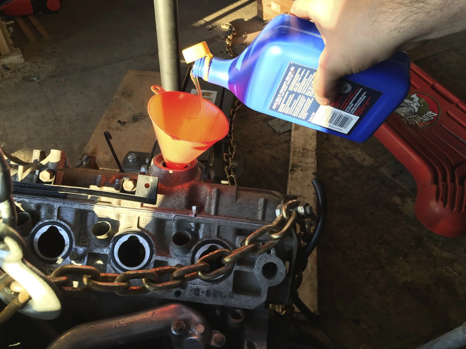 The first of six quarts of oil being power into the engine.