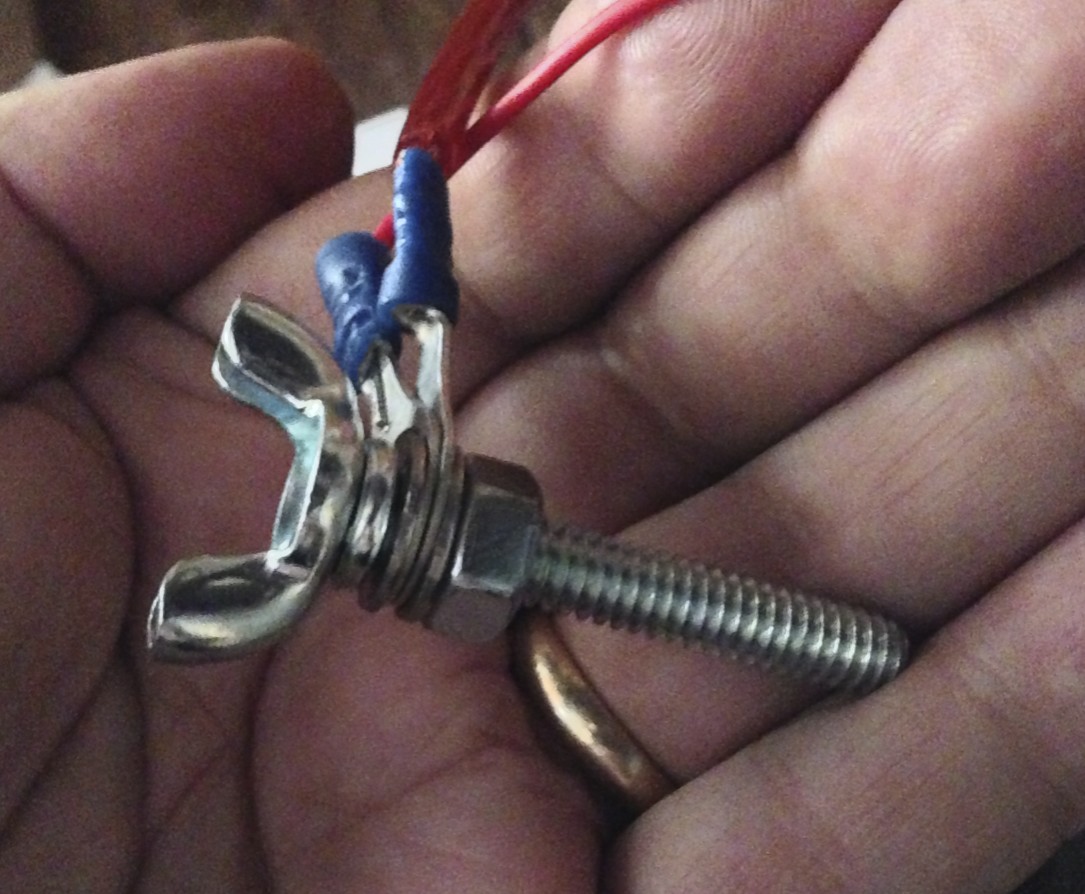 A wingscrew and nuts holding the lighting wires in place.