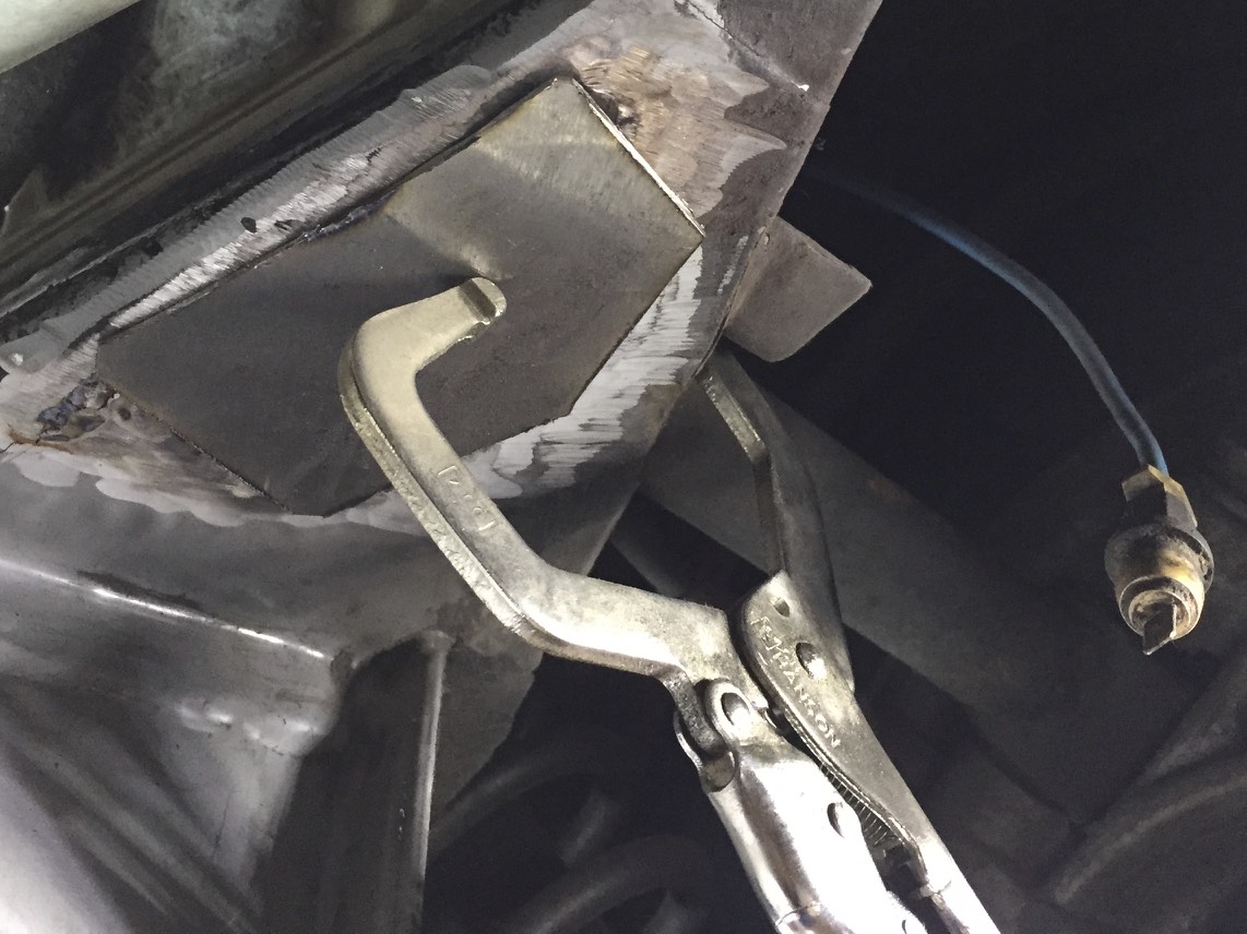 The patch clamped against the frame, ready for welding.