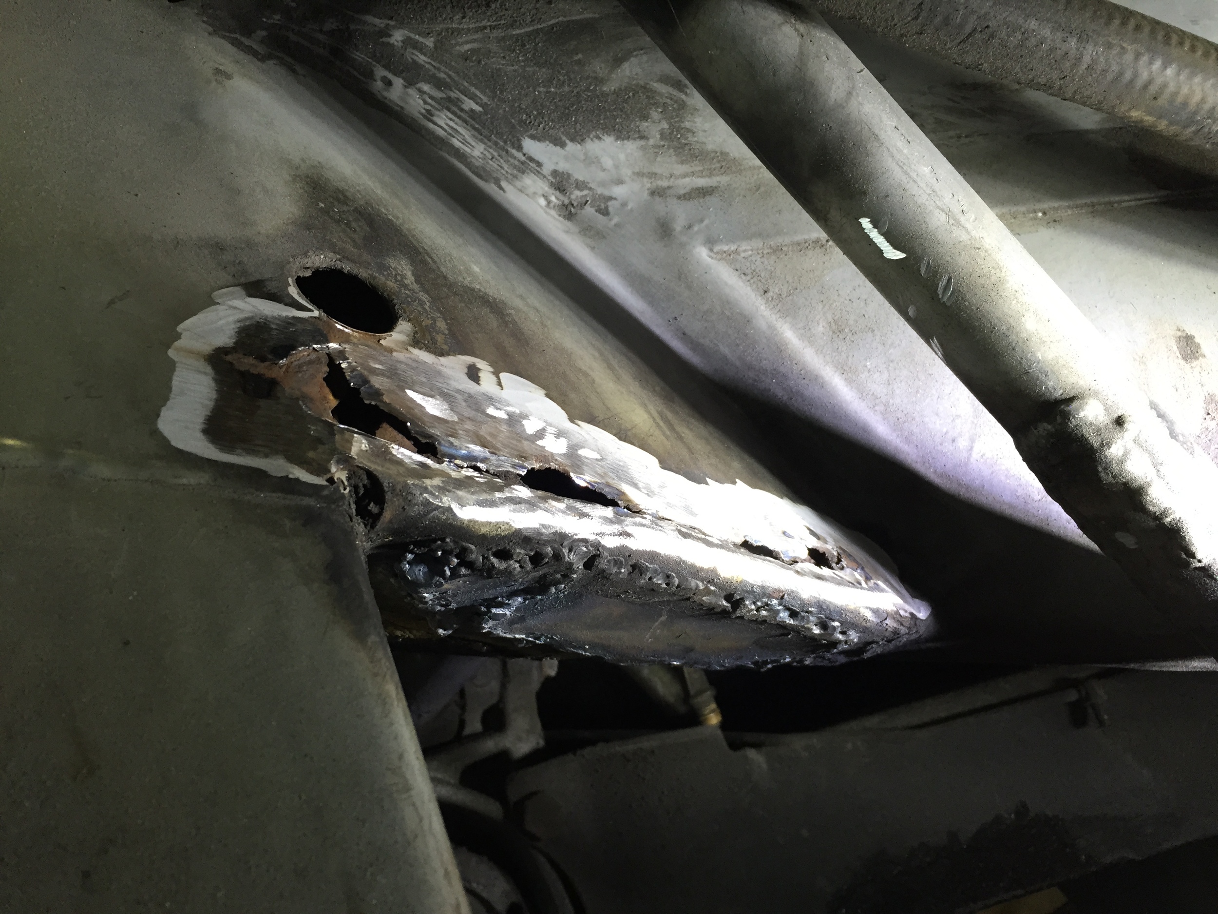 A closer view of the hole, and the previously-welded patch below it.