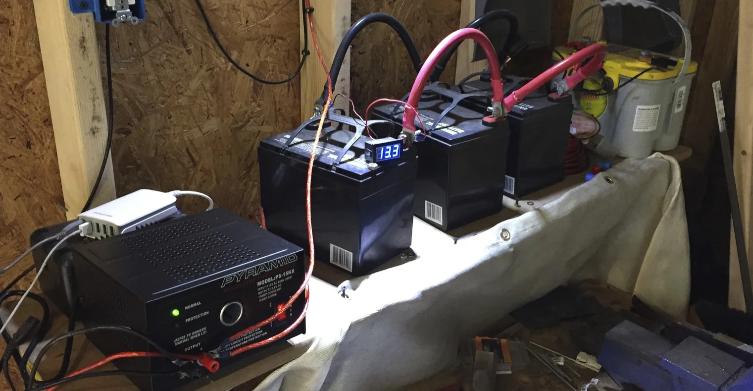 The power inverter (bottom) powers the lights instead of the batteries. The batteries are constantly being charged by the battery charger (behind the inverter), and a five port USB power supply (white box) keeps my phone and headset charged up.