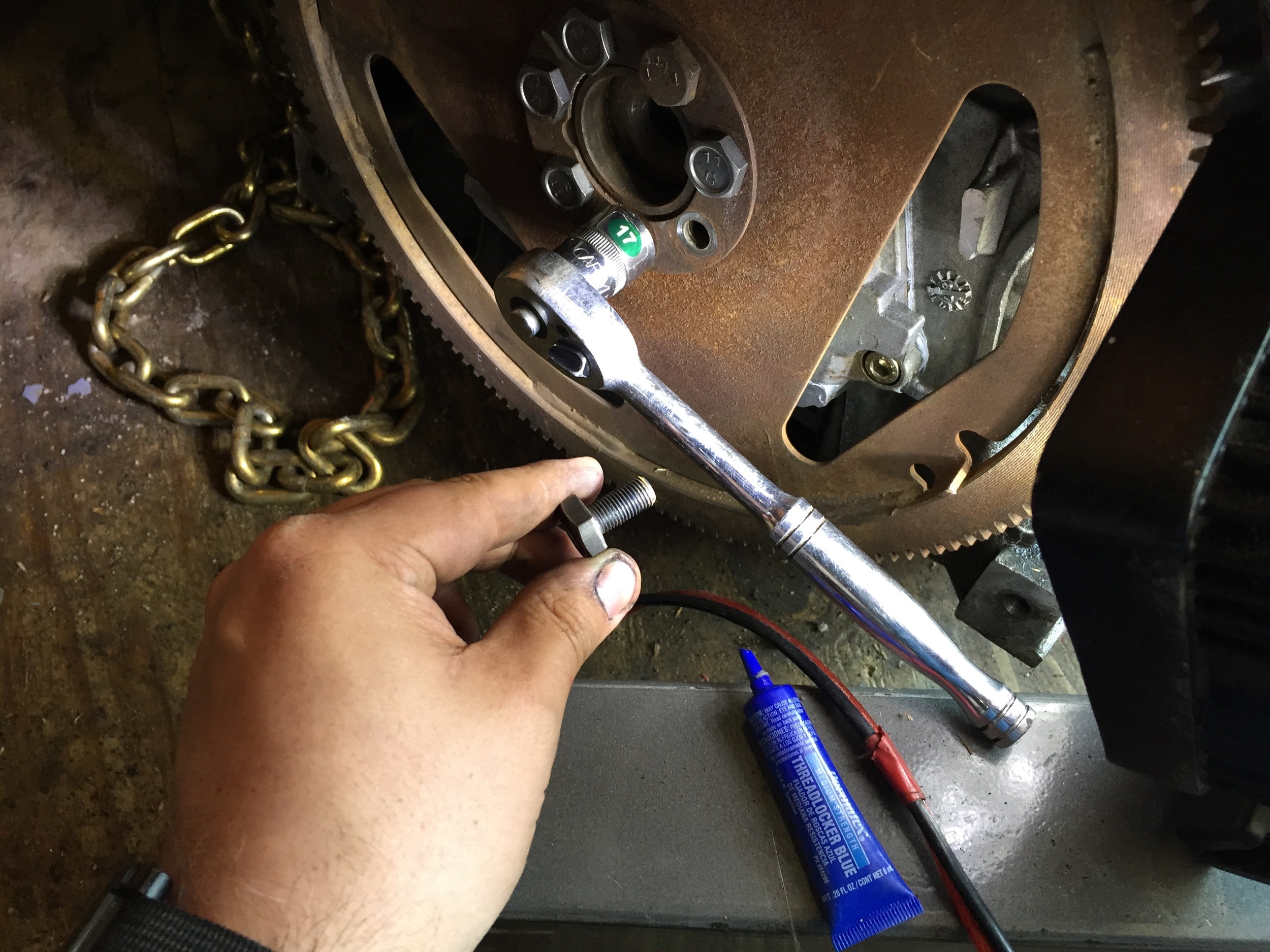 Installing the new bolts on the flex plate with a 17mm socket and blue Locktite.