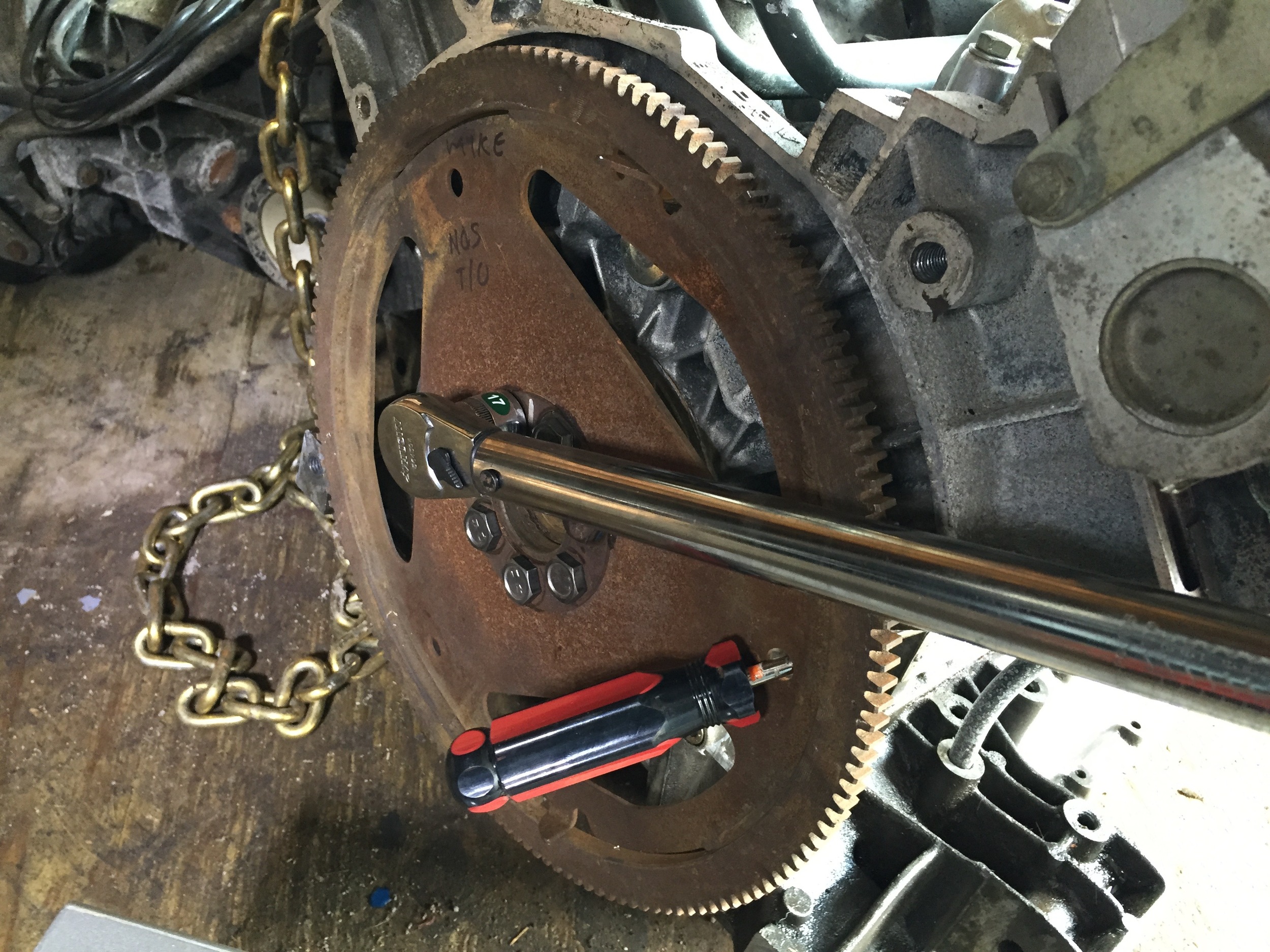 Torquing the flex plate bolts, with a screwdriver wedged against the engine to keep the crank from turning while tightening.