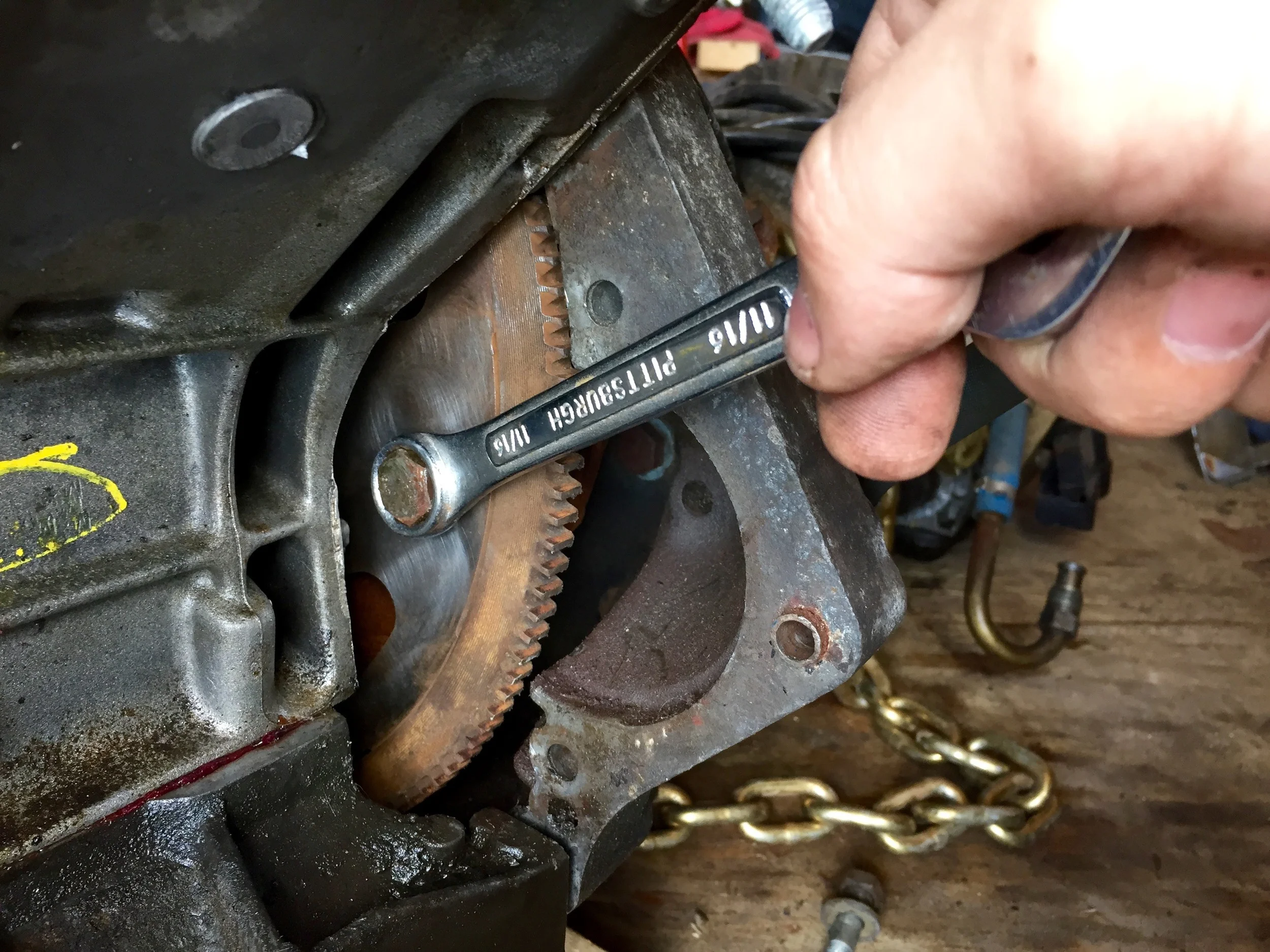 Tightening one of the bolts that holds the flex plate and torque converter together. A socket only fits at a very specific crank rotation, so I used a box wrench to start.