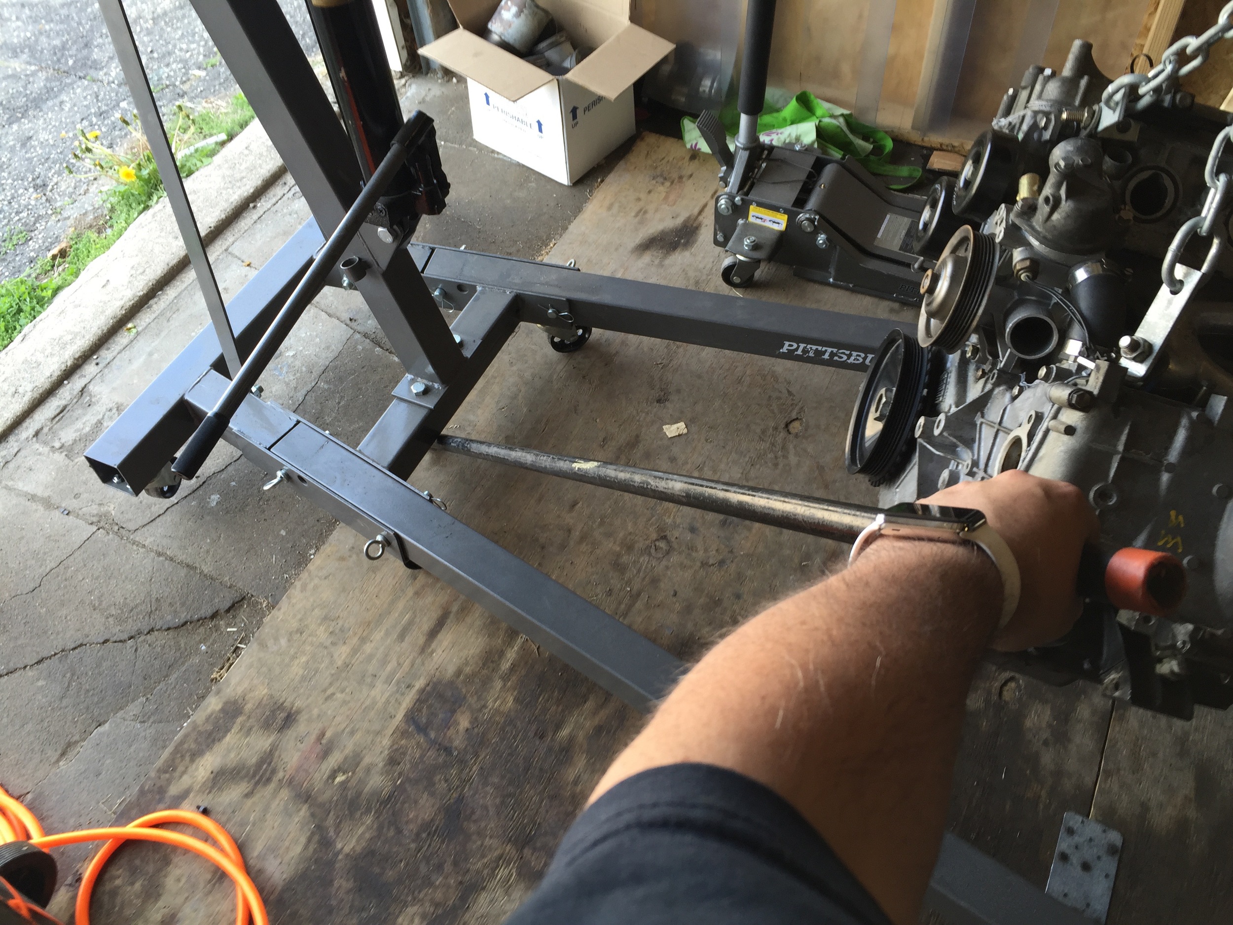 Using a pipe as a lever to more easily move the lift around. The lift was pushed so far back that the back wheels were no longer on the plywood I used to create a smoother temporary floor.