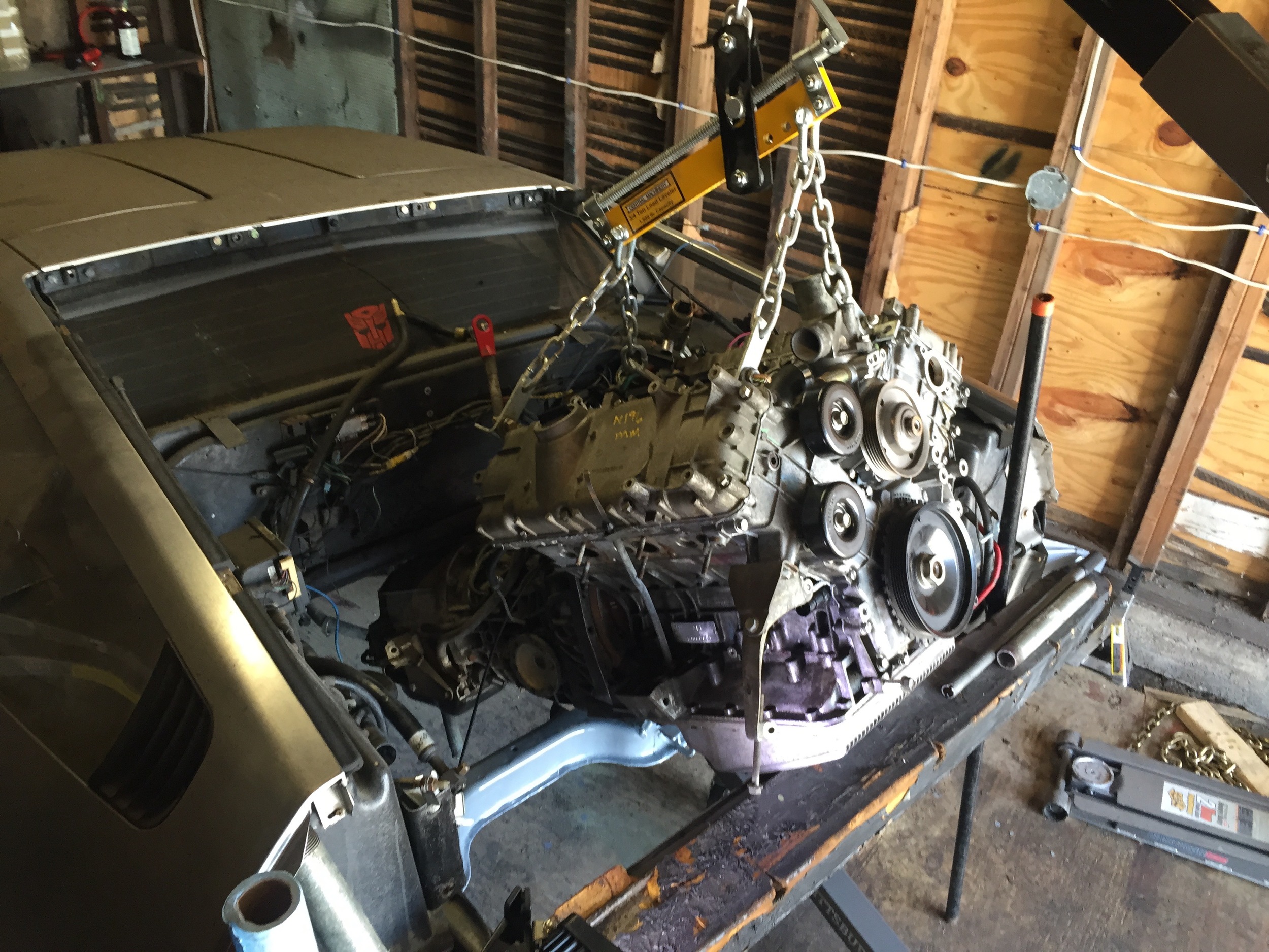 The engine partially lowered into the compartment.