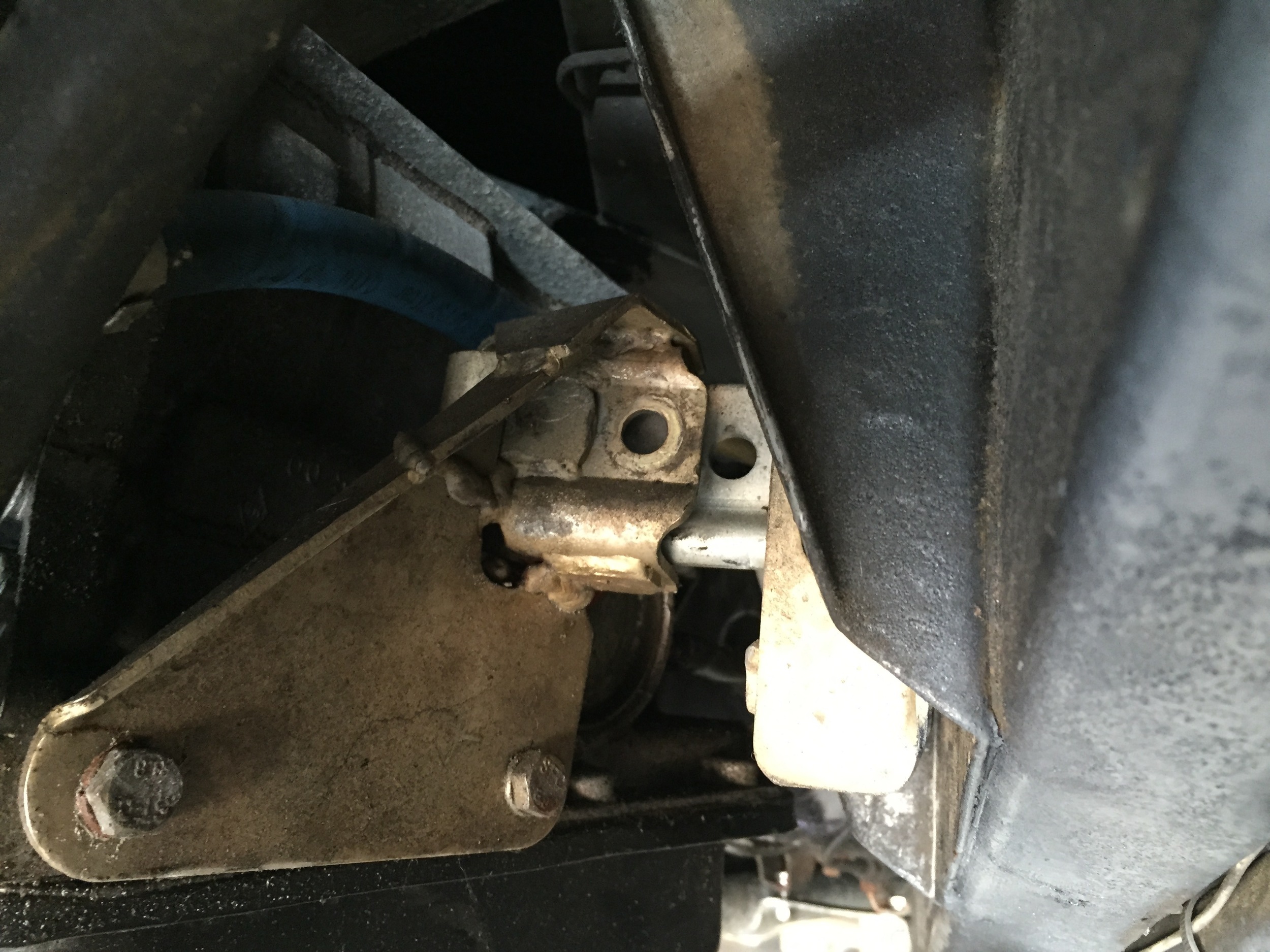 The golden C-like bracket on the transmission mating the mount on the frame behind it. The transmission needs to be shifted a bit to the right so that the holes line up, but otherwise it's in position.