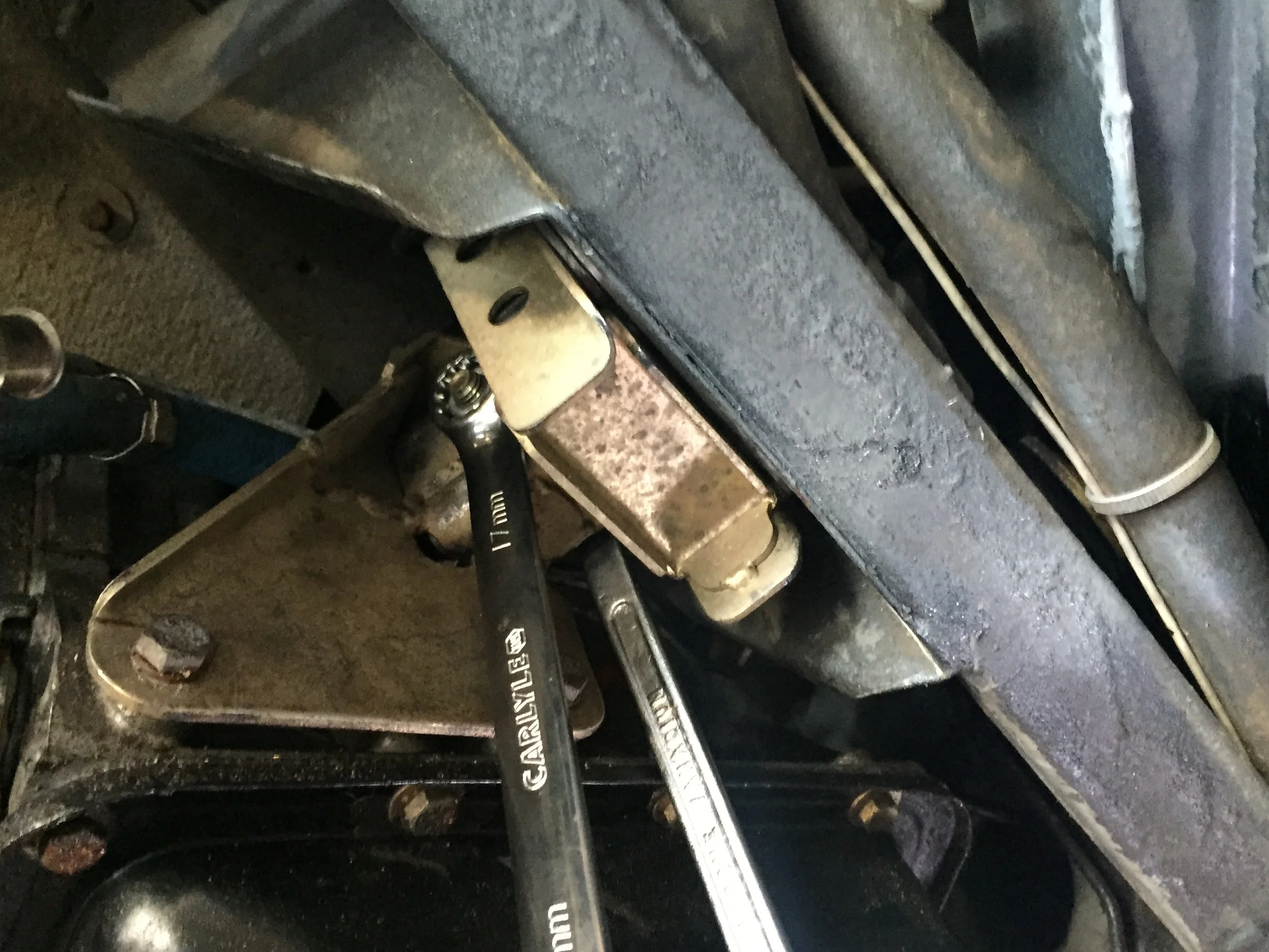 Tightening the transmission to the mounts with two 17mm wrenches (view looking up from below).
