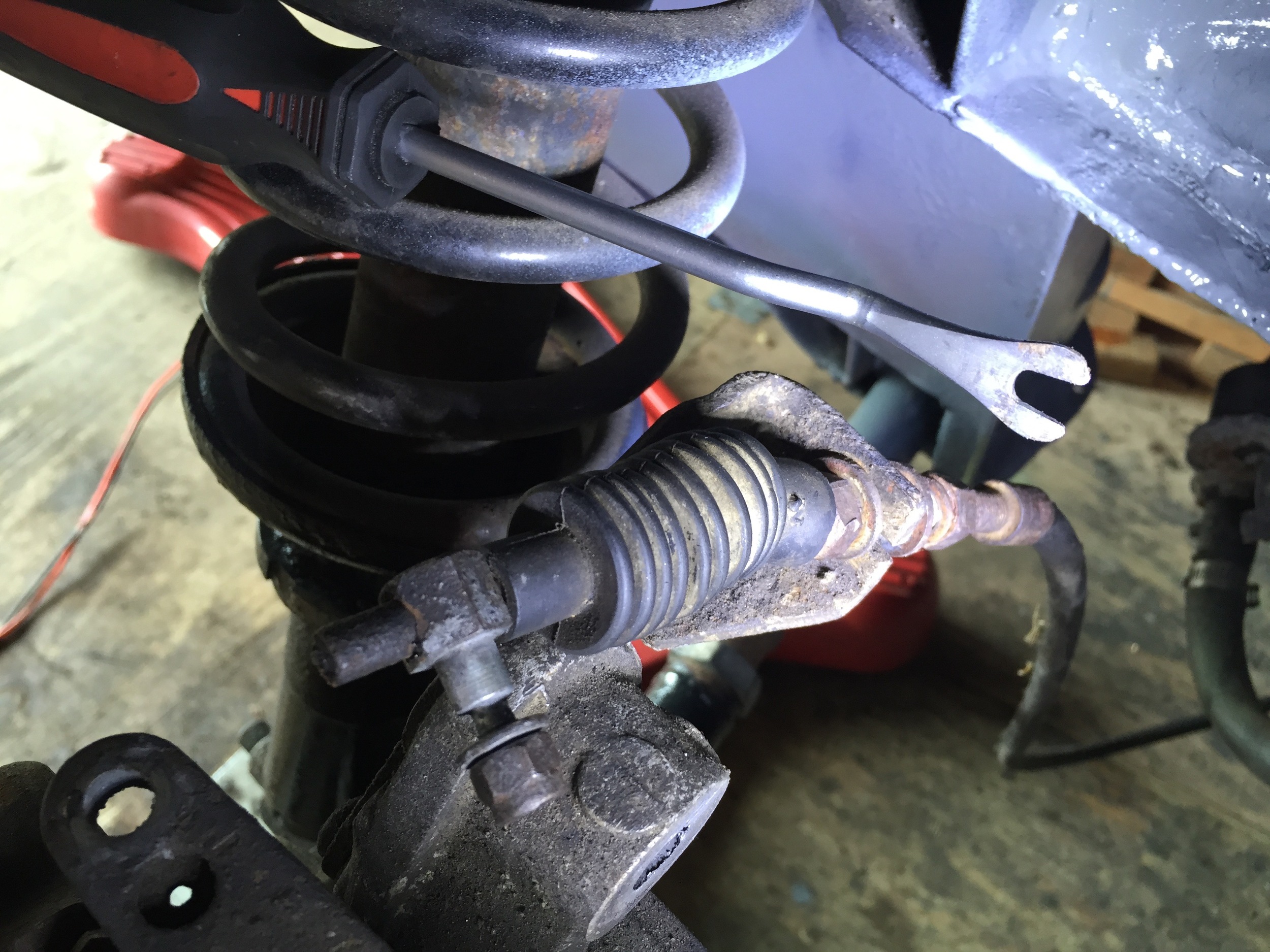 The cable reinserted through the slot in the bracket. The slotted pry bar above was used to more easily compress the string to reveal the cable.