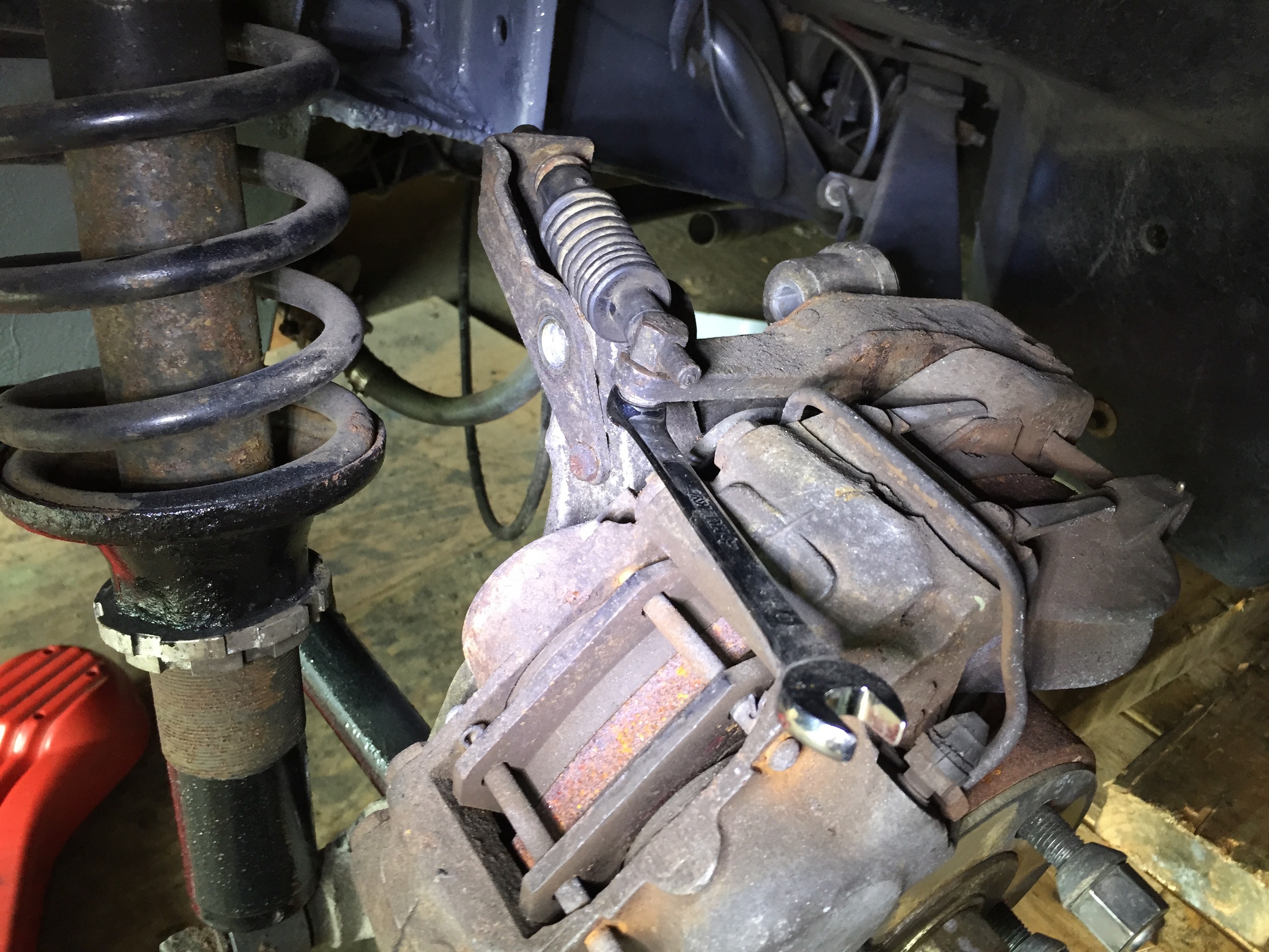Using an 11mm wrench to whiten the end of the cable to the brake.