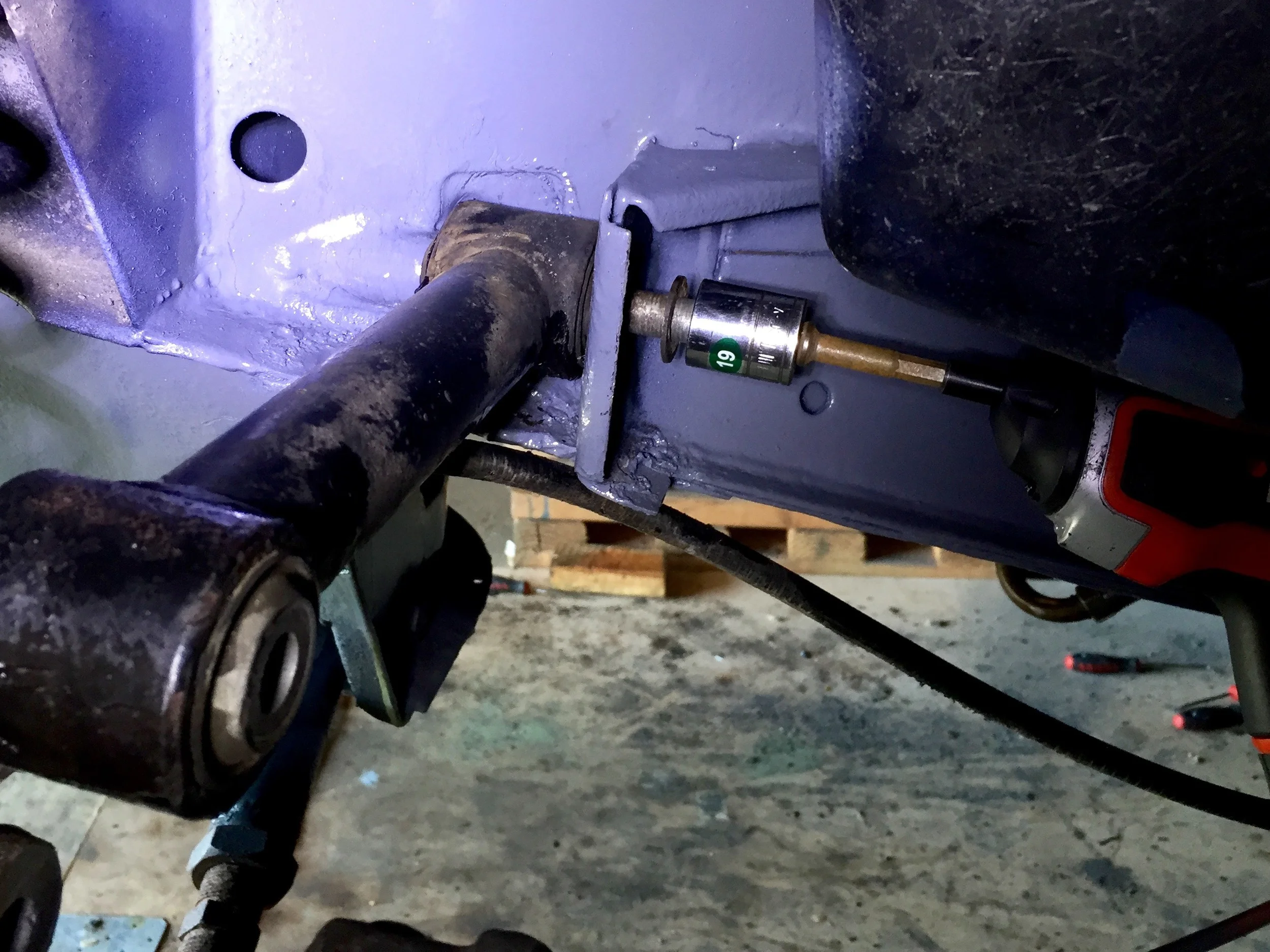 Using a 19mm socket on power screwdriver to turn the bolt. While the driver ran, I tilted the arm up and down until the bolt caught on the threads in the frame.