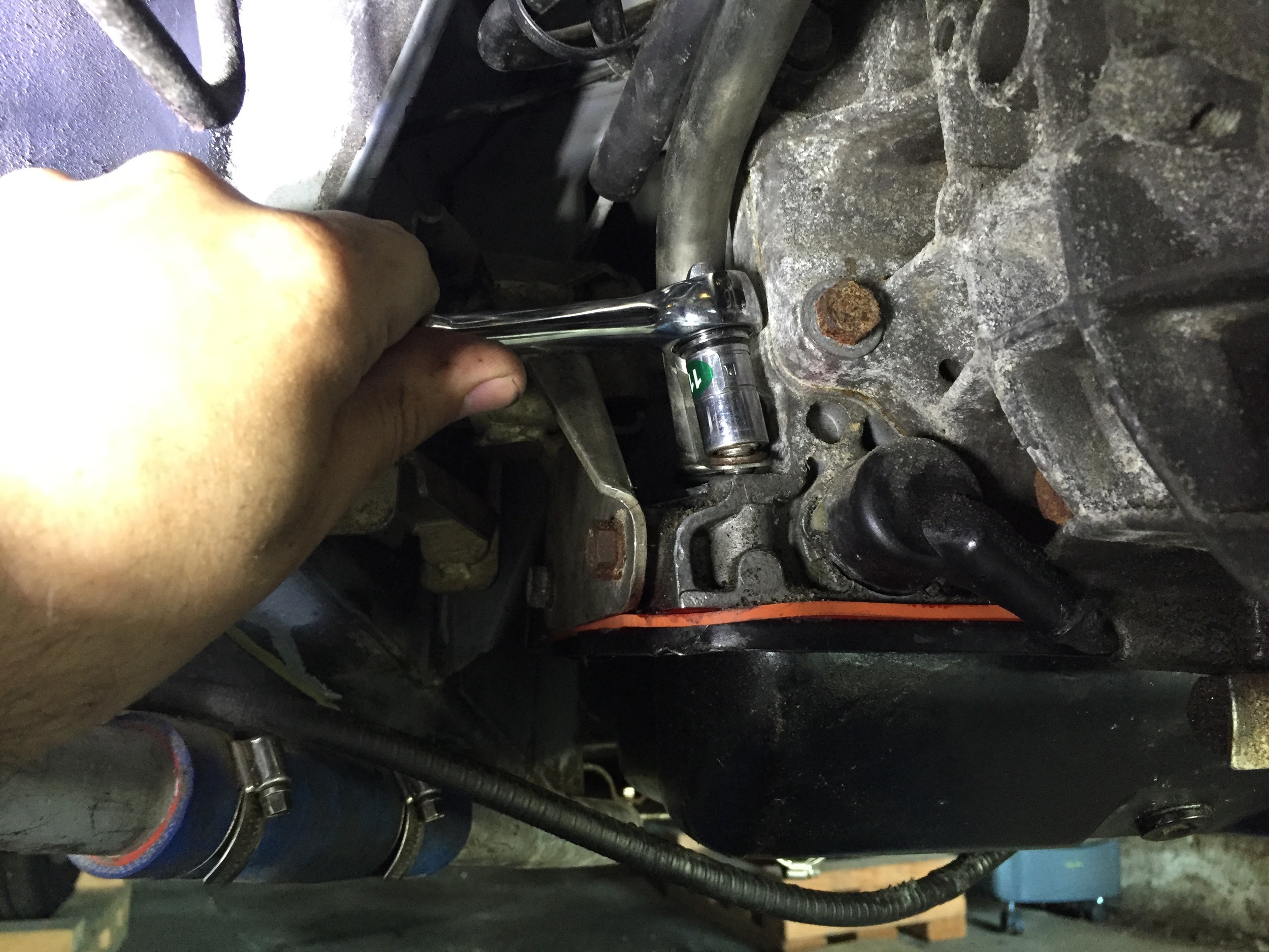 Tightening the lower bracket bolt with an 11mm socket.