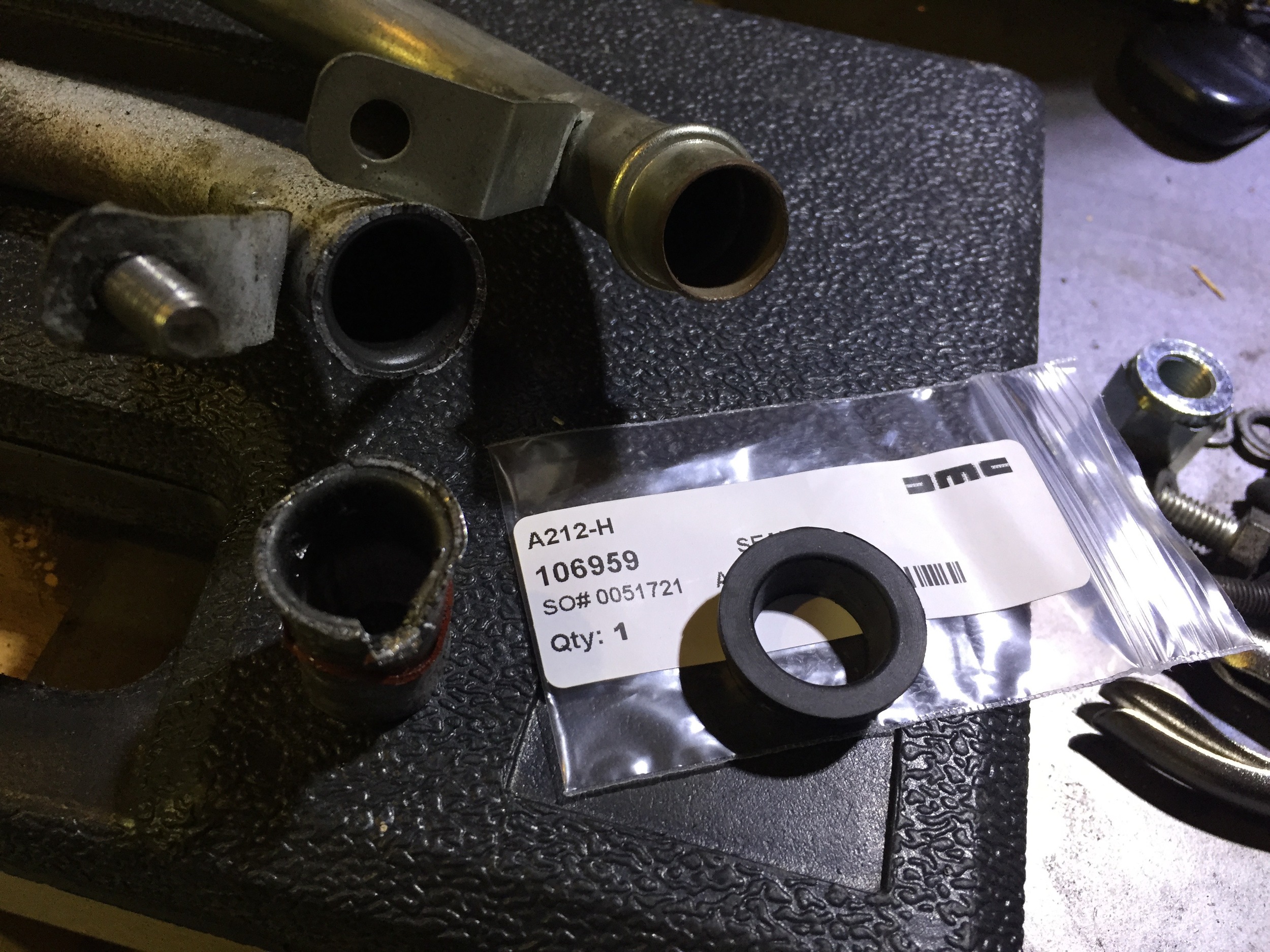 The broken tube (to left) and the piece I pulled out of the transmission (bottom left) next to the new tube (top) and the otterstat seal (bottom right).