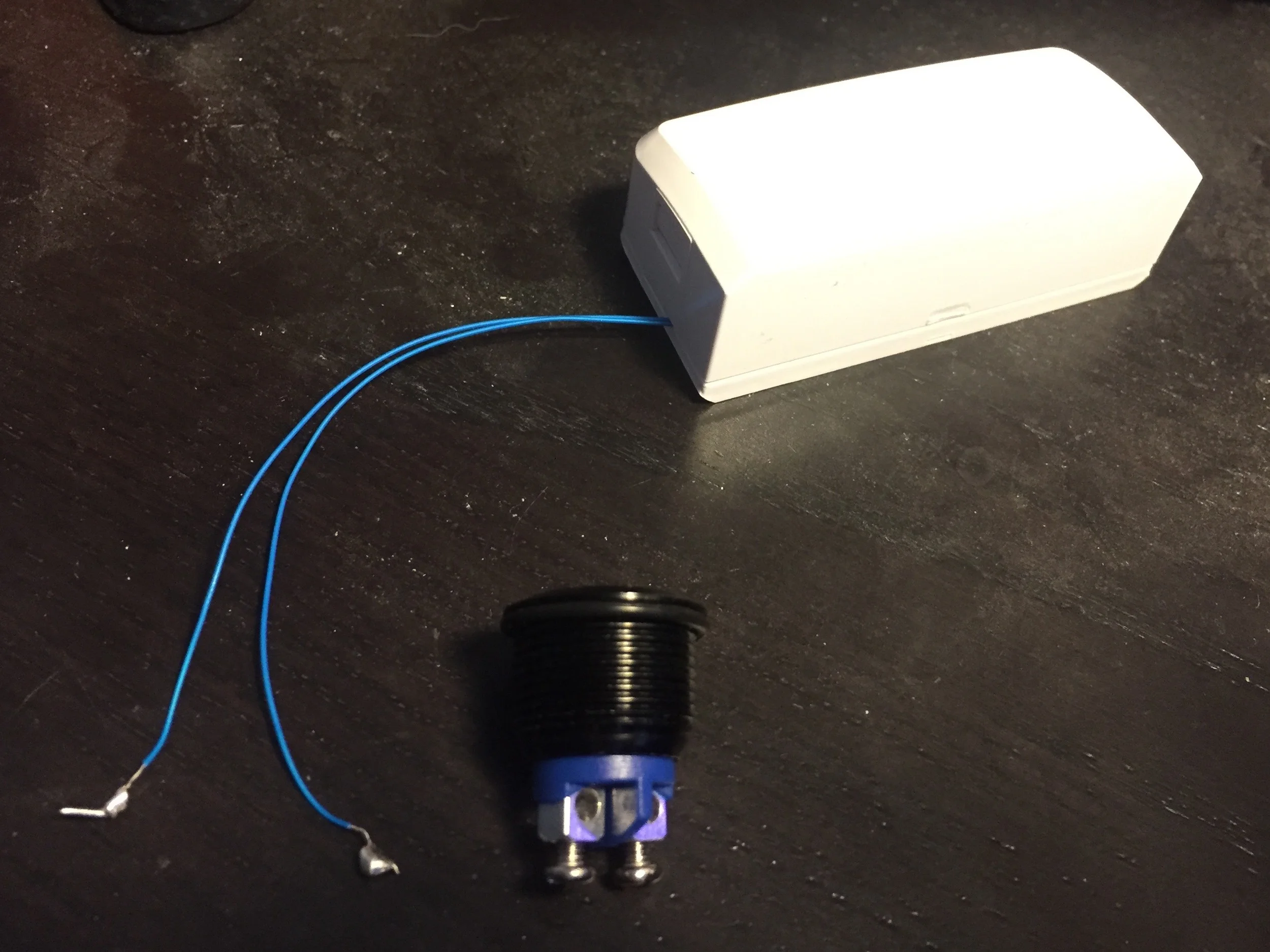 Assembled Multi-Sense with the wires sticking out the sides and a push button for testing.
