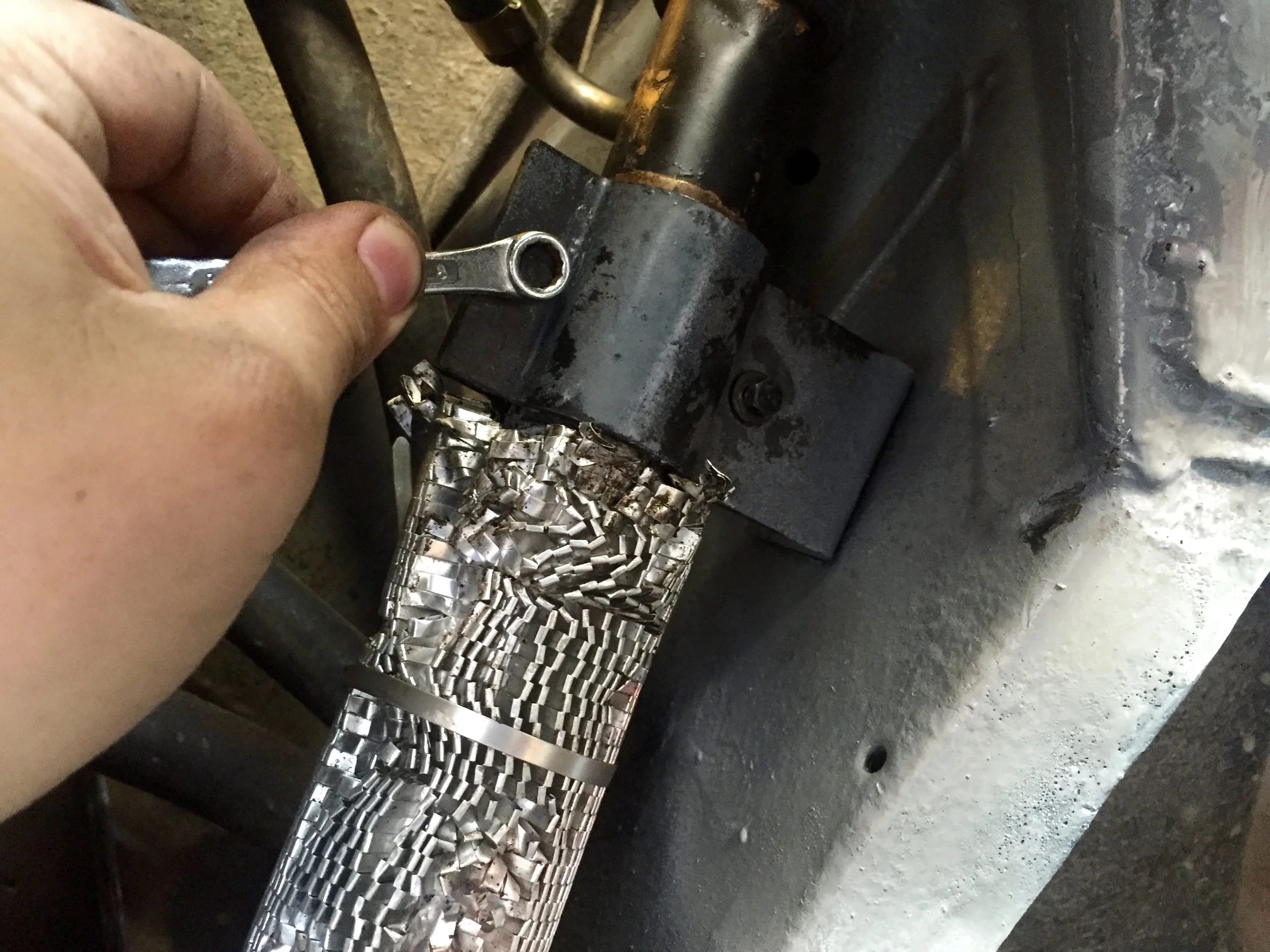 Securing the coolant pipe to the bracket with an 8mm socket.