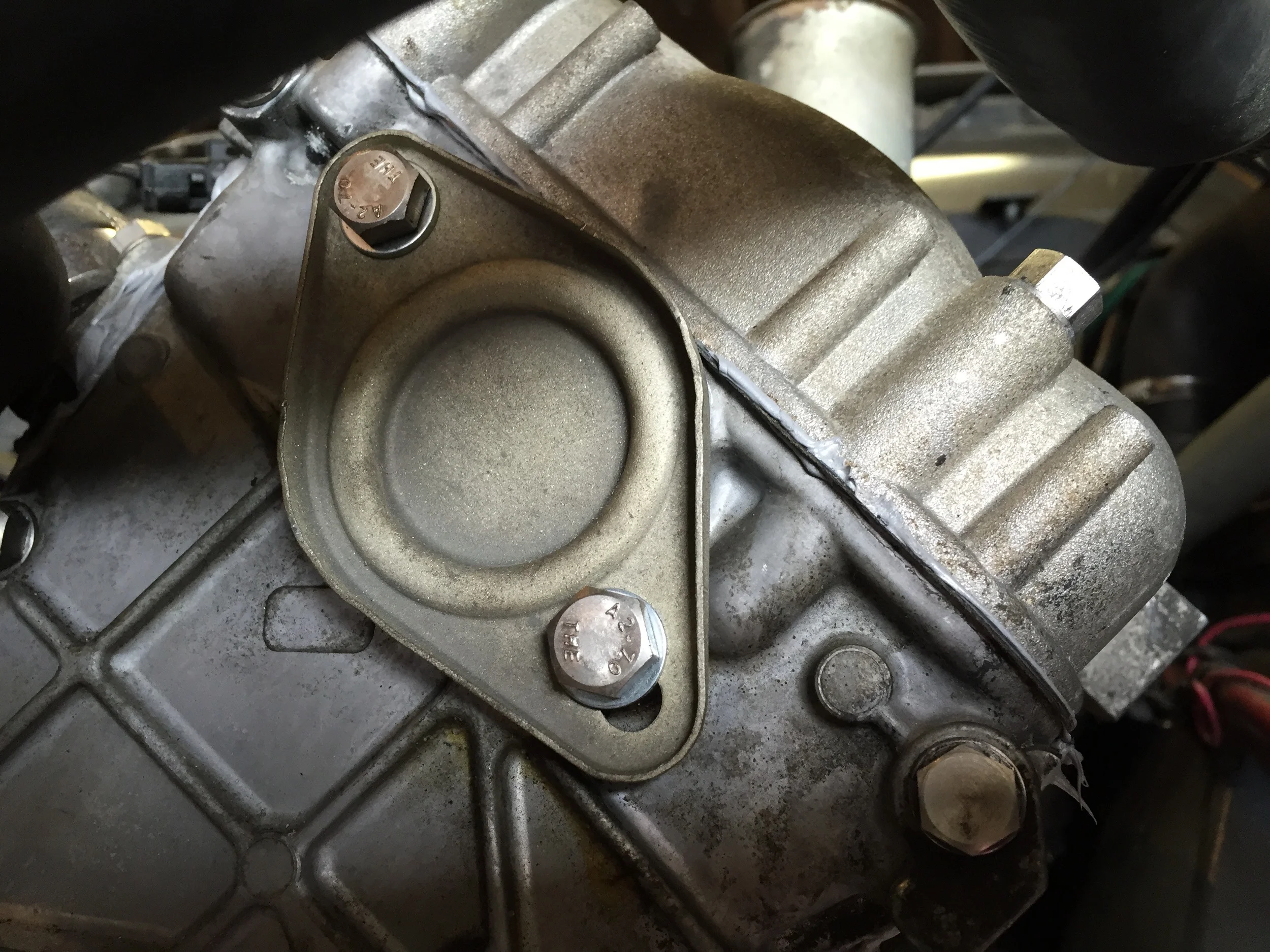 Final installation with an O-ring under the cap and two bolts securing it to the head.