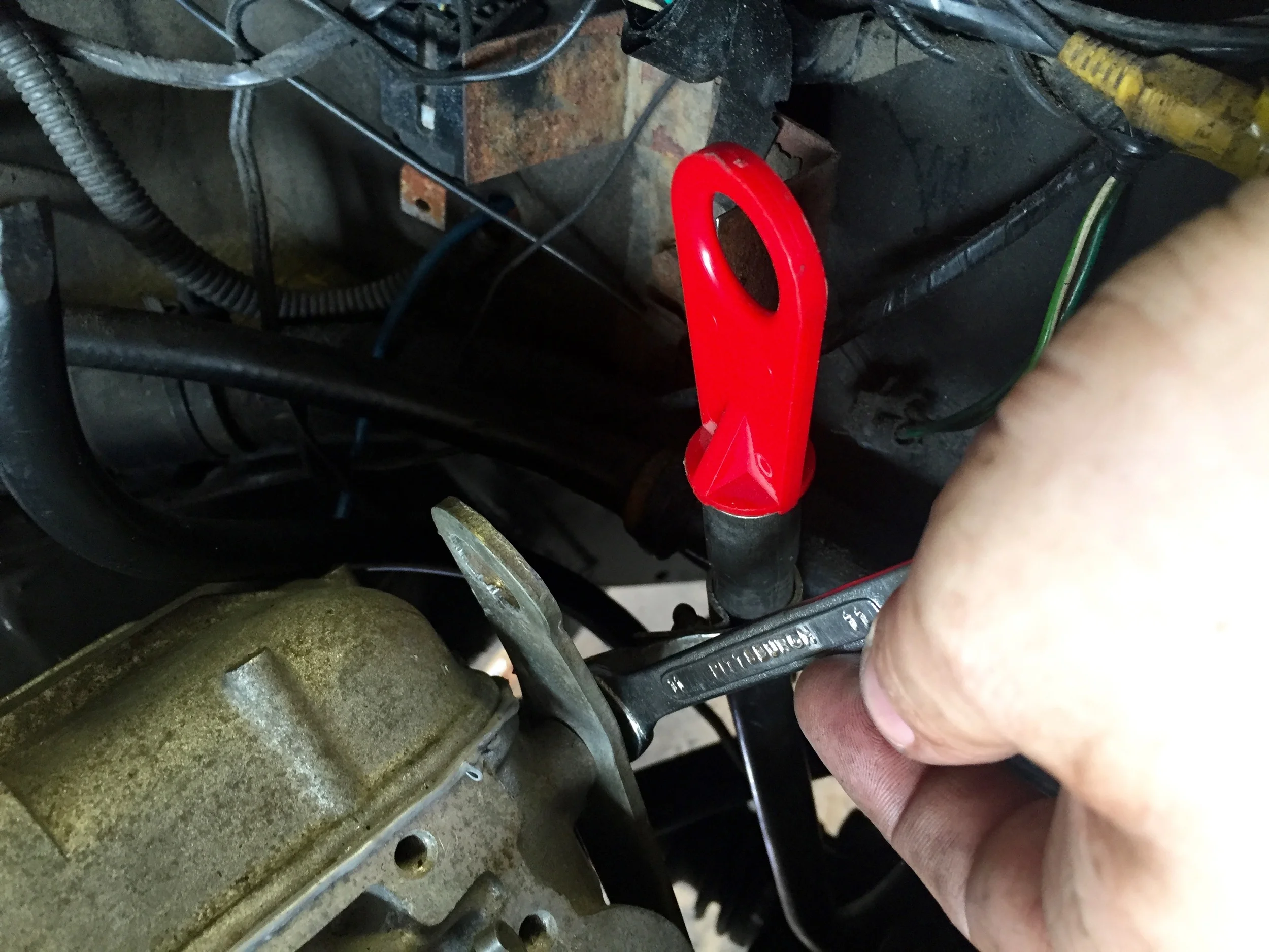 Attatching the dipstick tube to the back of the cylinder head with an 11mm wrench.