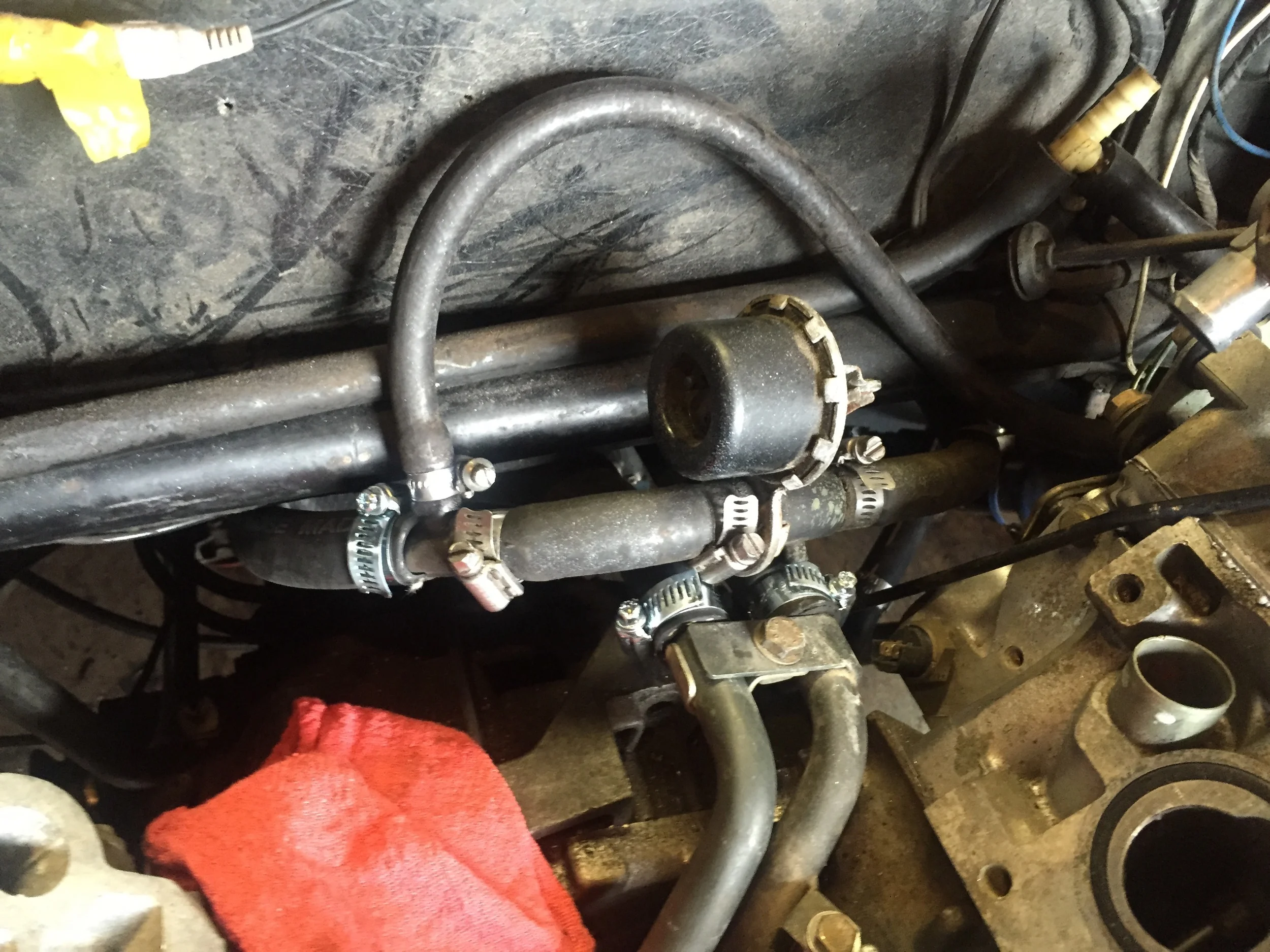 First attempt at installing the heater lines. The hose with the hot water valve (large cylinder) loops around in an odd way to the drivers side (left in the picture) water pump line, and kinks under the fiberglass body.