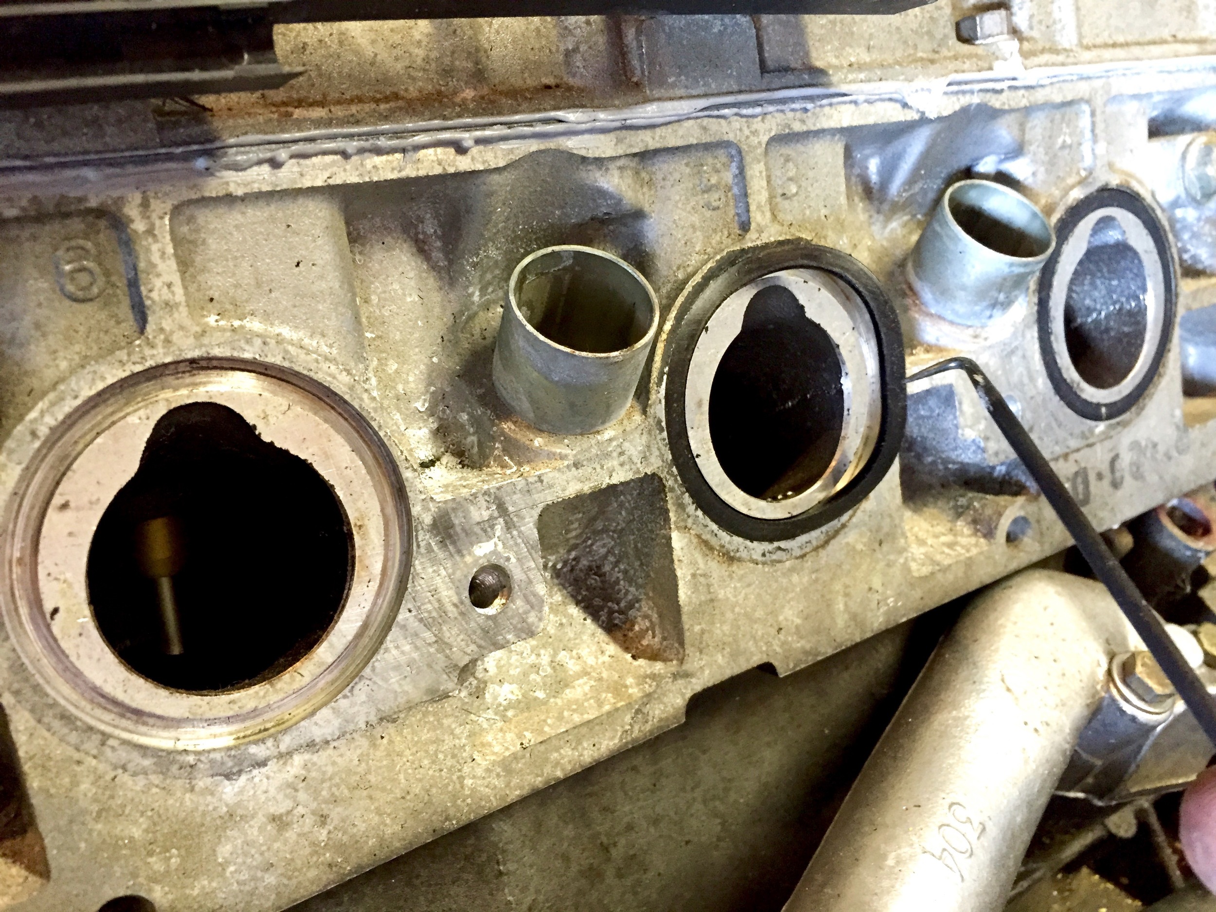 Using a pick to remove the old O-rings from the cylinder heads.