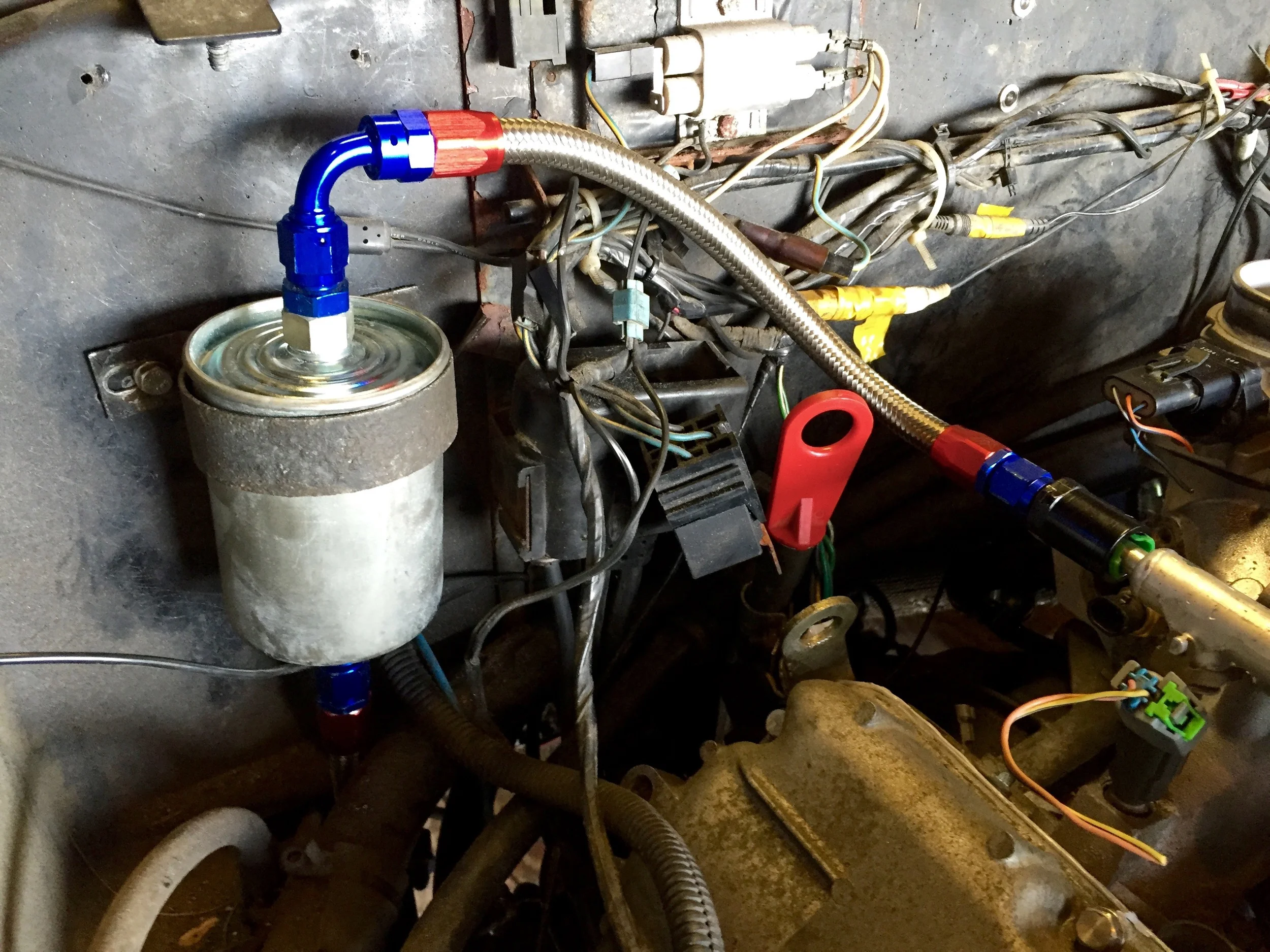 The fuel filter mounted on the bulkhead, with a fuel line running from it to the end of the fuel rail.