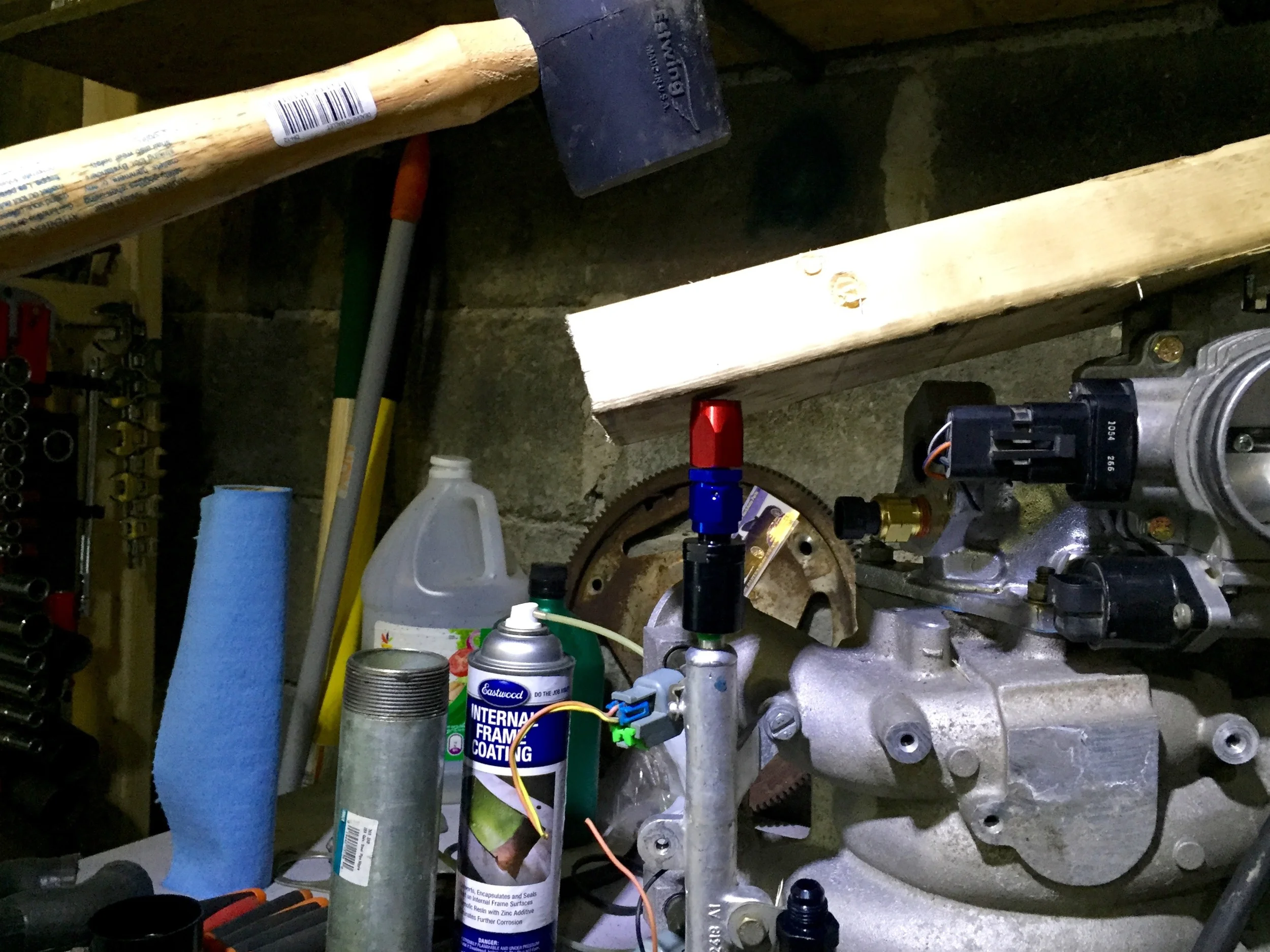 Getting the new metal connector on involve a rubber mallet (top), a piece of wood (middle), a fuel fitting (red/blue) and the connector itself (black) on the end of the rail (bottom).