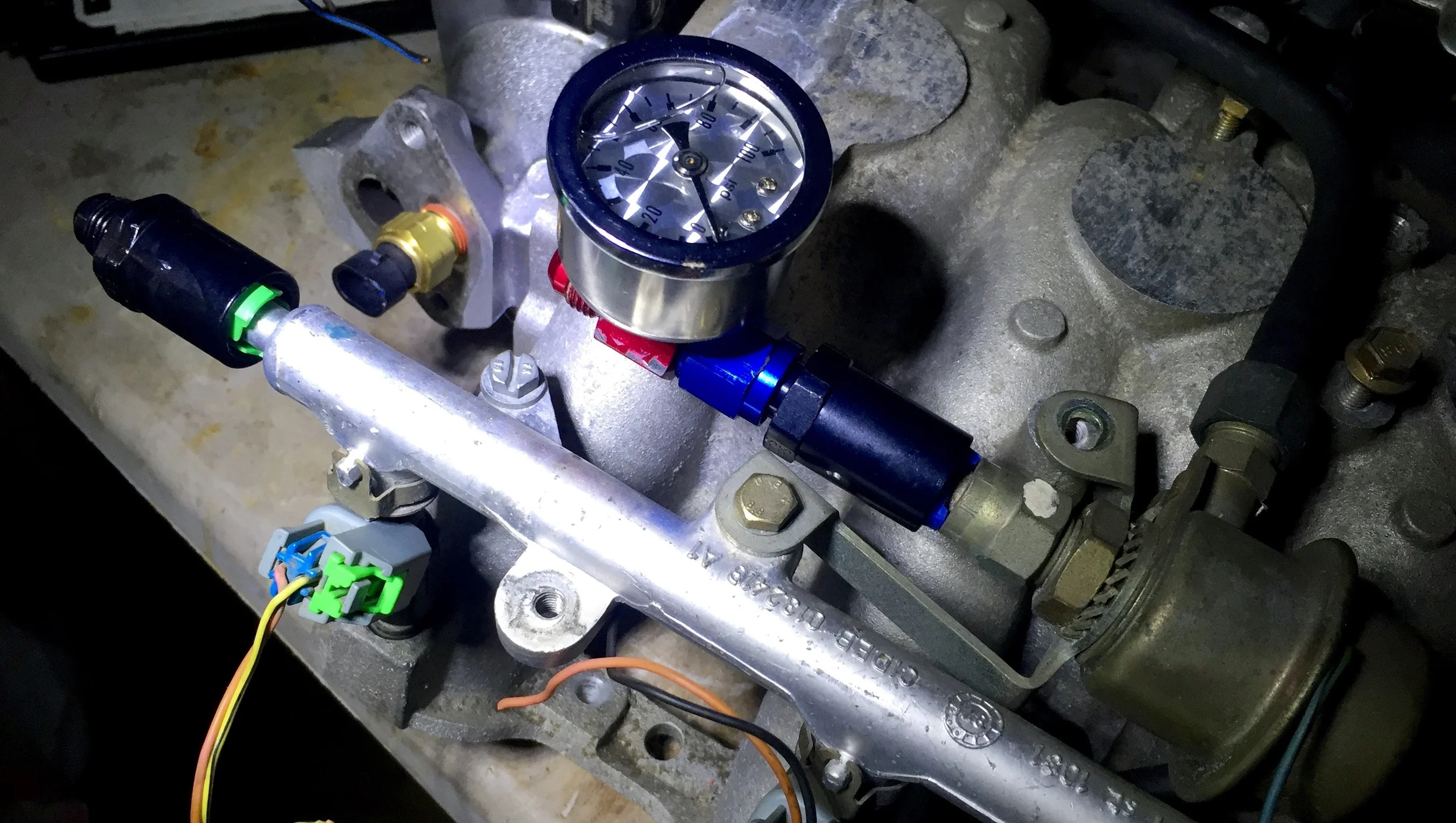 The fuel pressure gauge mounted to the outlet of the fuel pressure regulator.