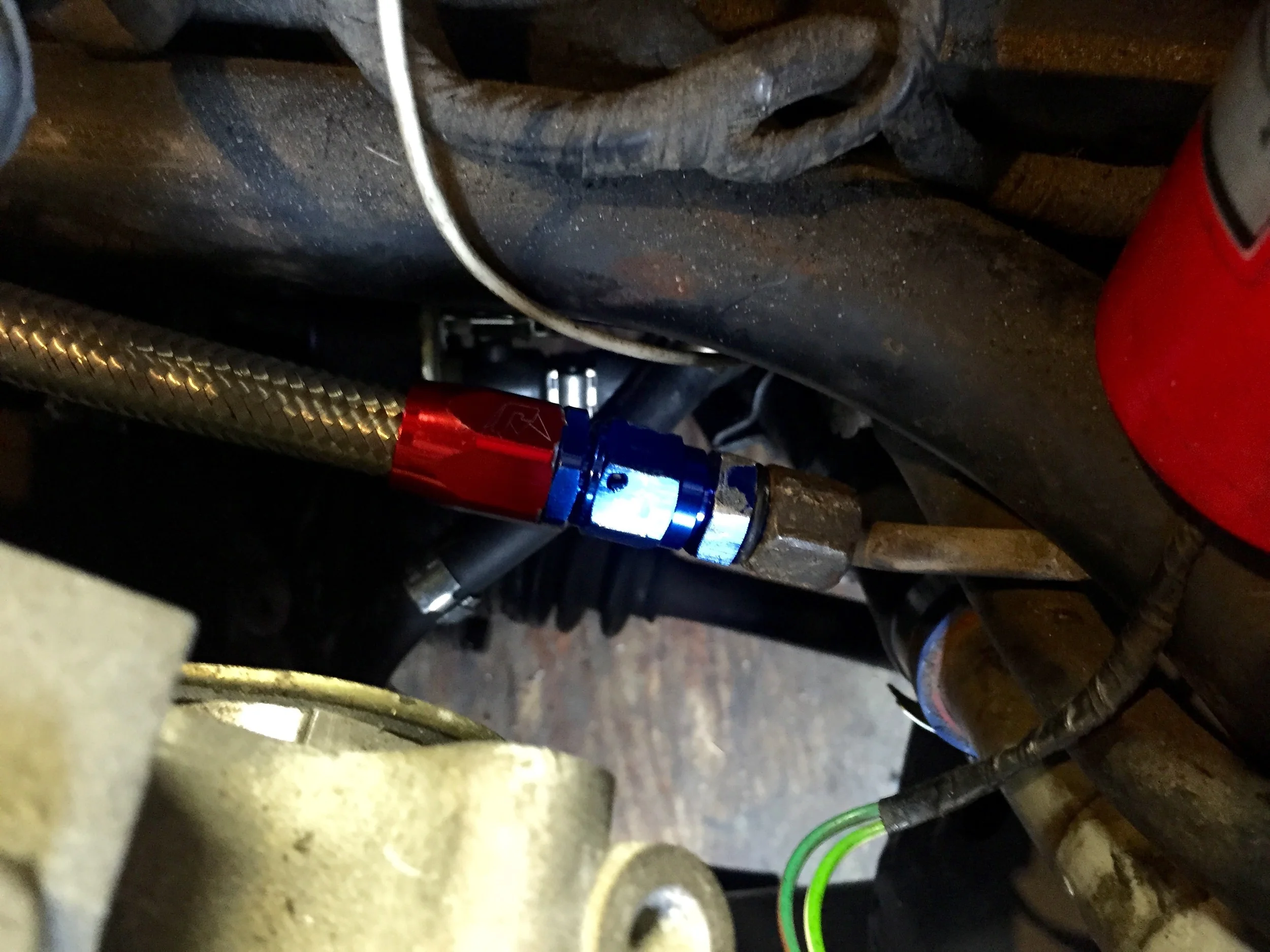 The return fuel line (red and blue connector) to the hard line dark grey connector) just below the old 2.8L ignition system's coil (red cylinder on the right).