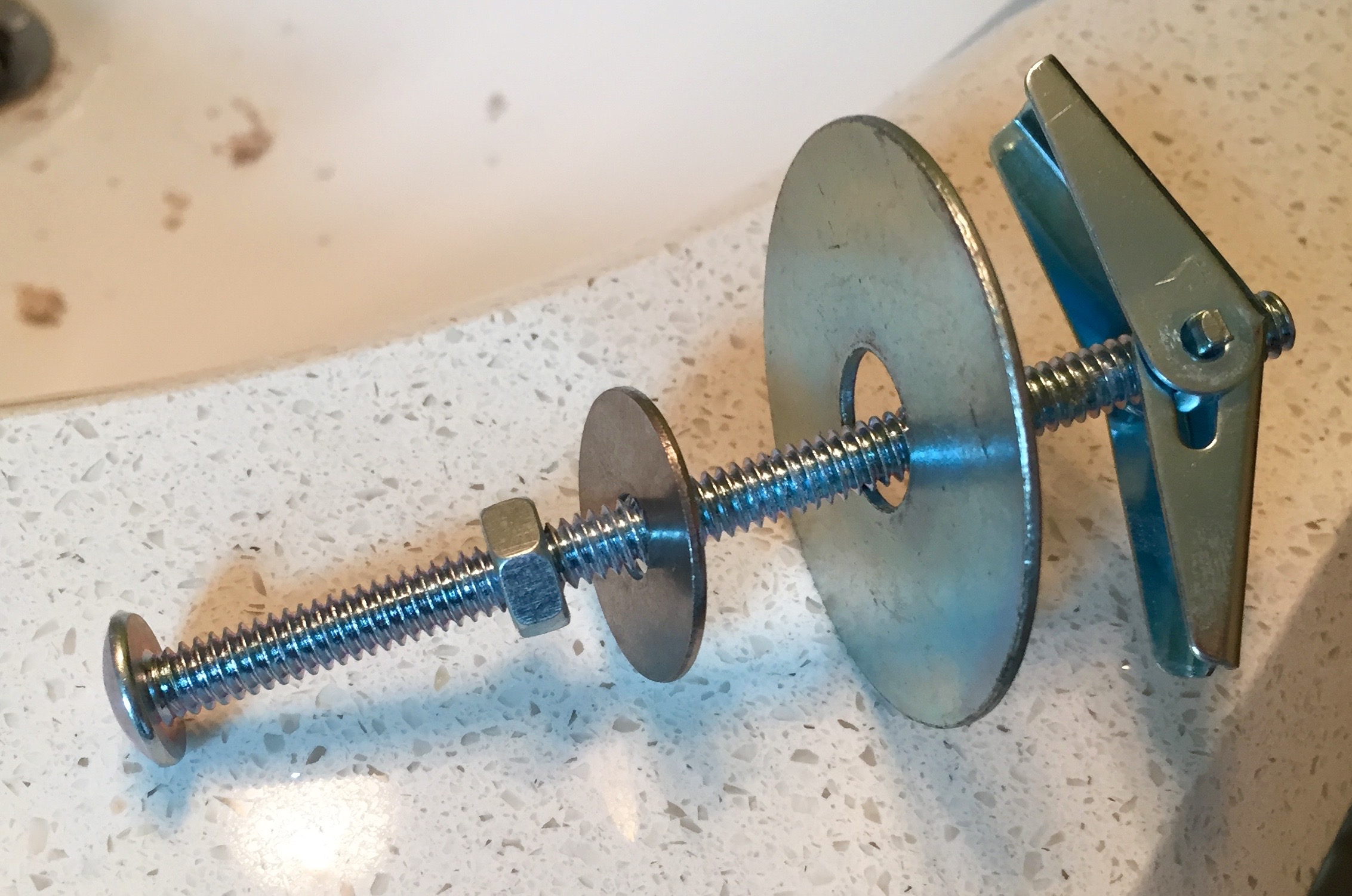 The combination of drywall anchor, nut and washers that became the studs that the mirror hangs off of.