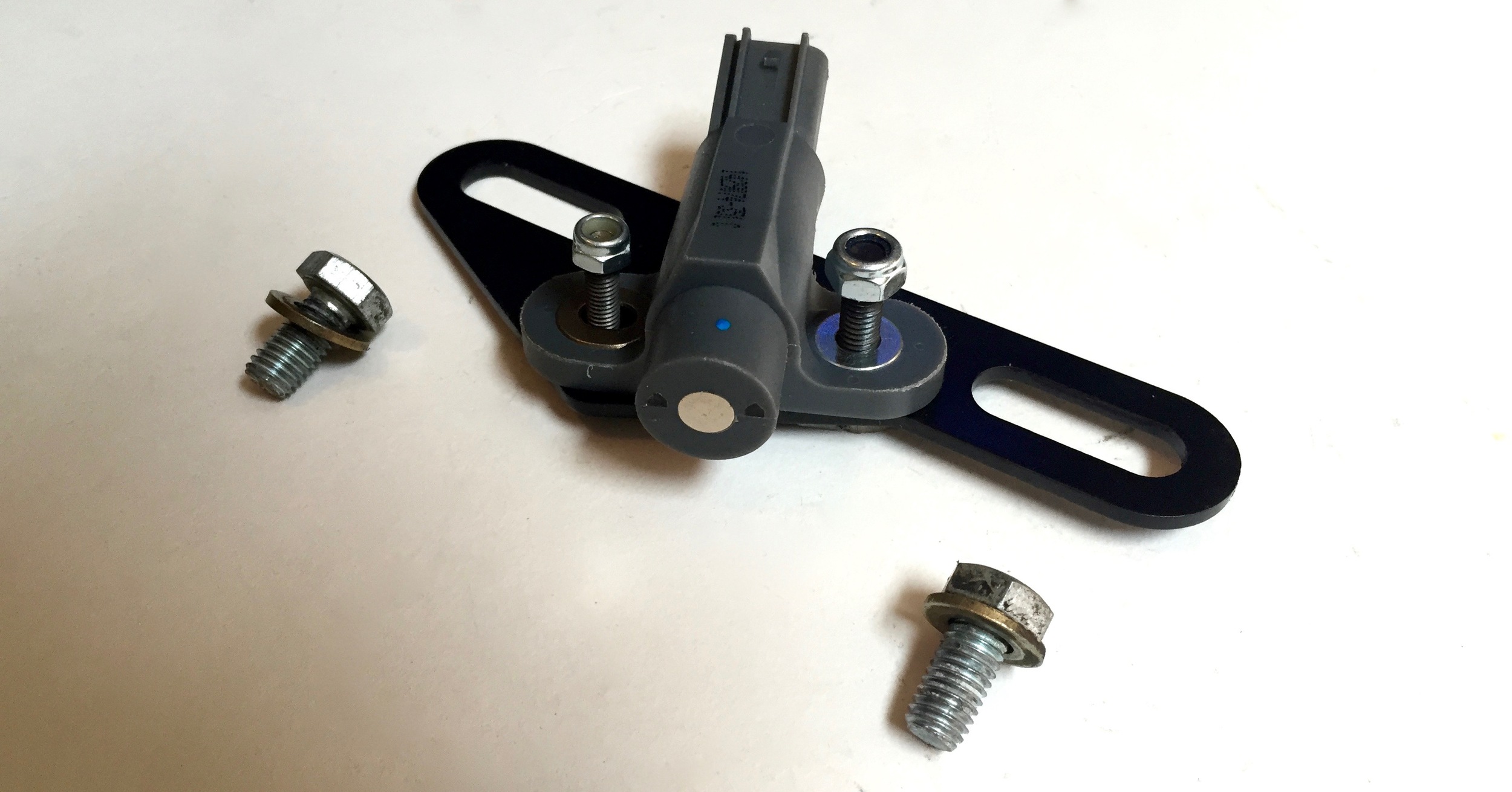 The VR sensor and its mounting bracket. The shiny disc is the magnet that sits near the missing tooth gear on the main crank pulley.
