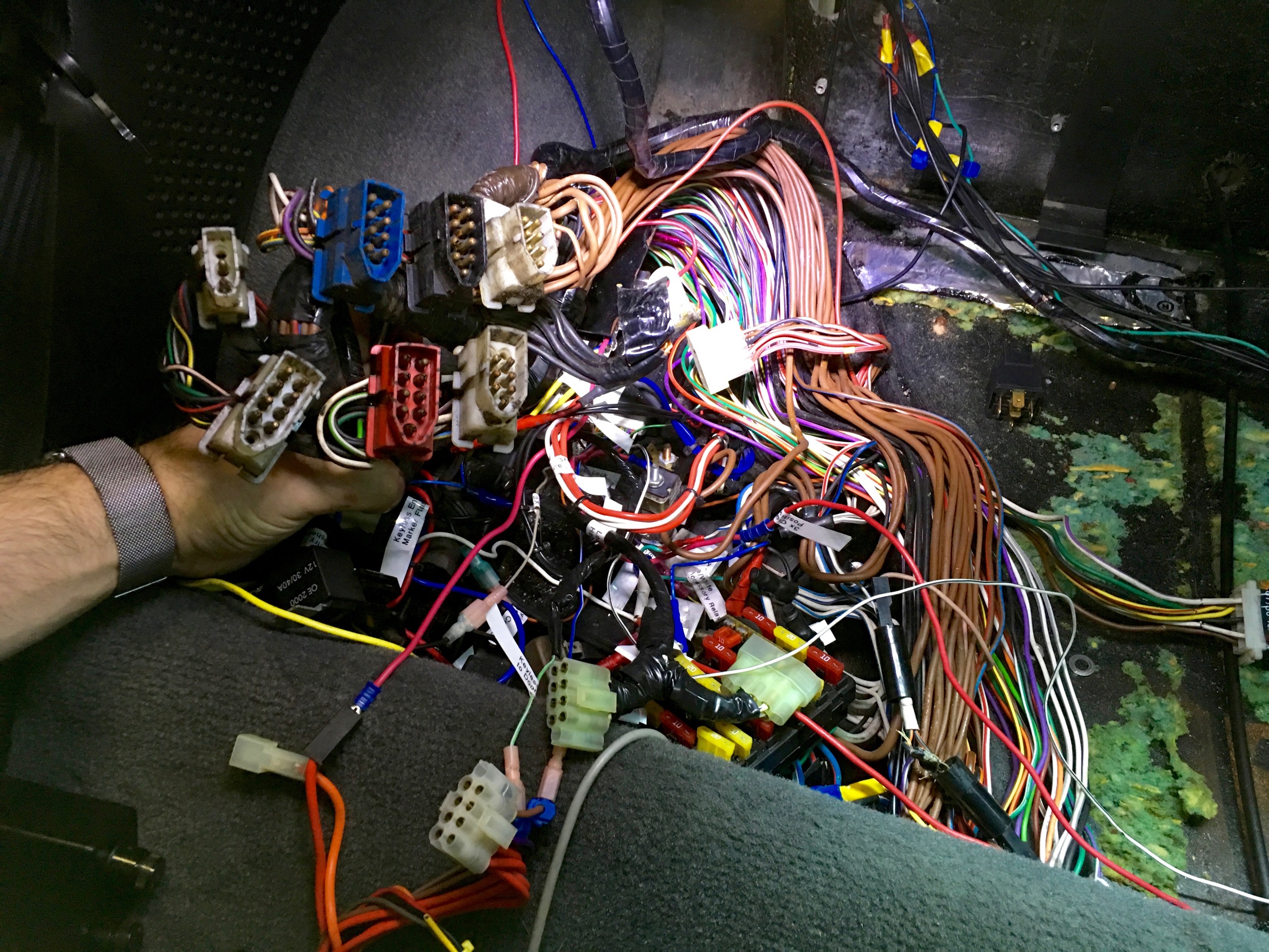 The bundle of liberated bulkhead connectors and unwrapped wiring harness in the relay compartment