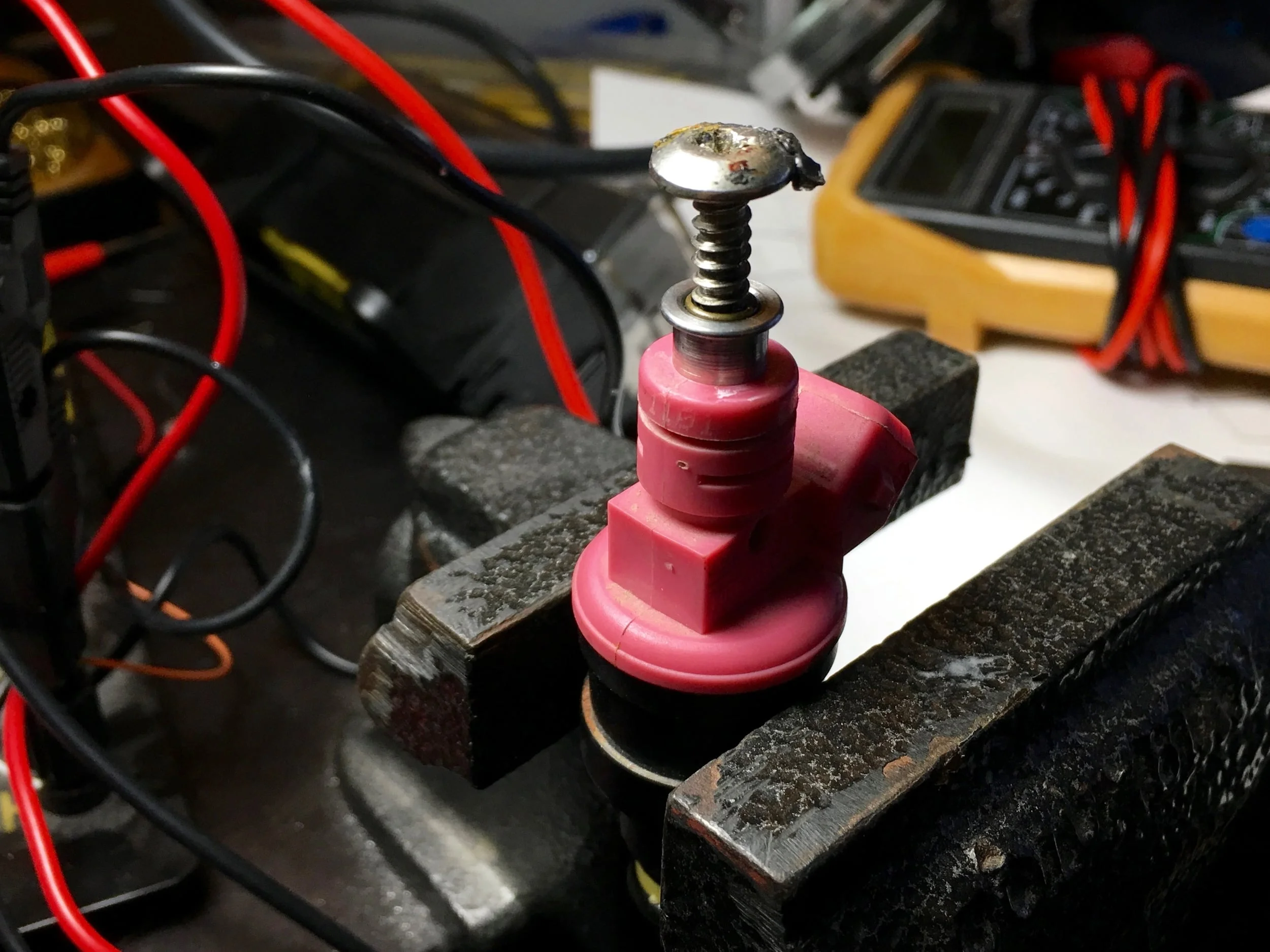The screw partially turned into the top of the old filter, before using pliers to rock the screw back and forth to lift the filter out.