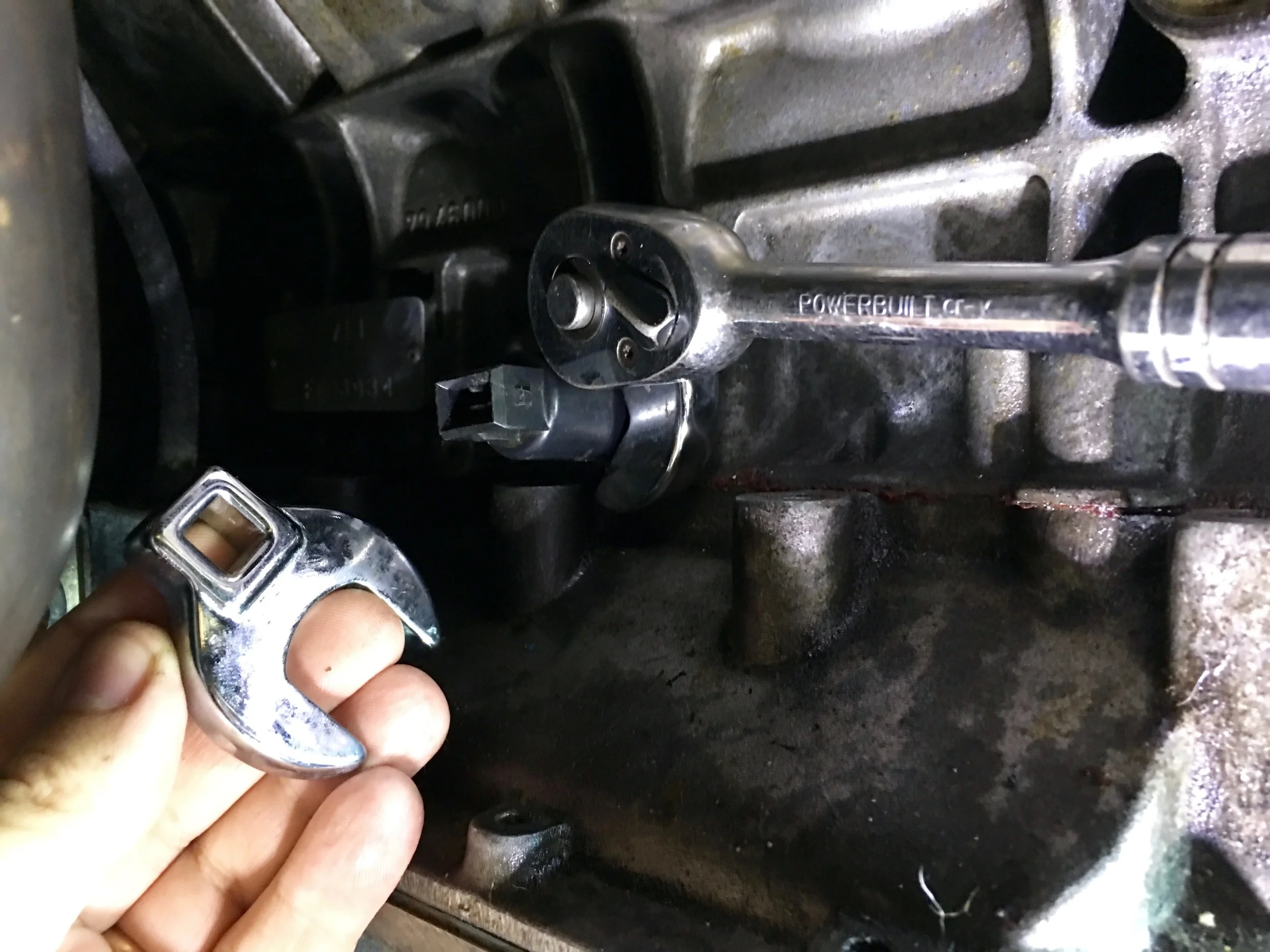 Using a 24mm crows foot wrench on a socket to secure the knock sensor. The sensor is otherwise unused.