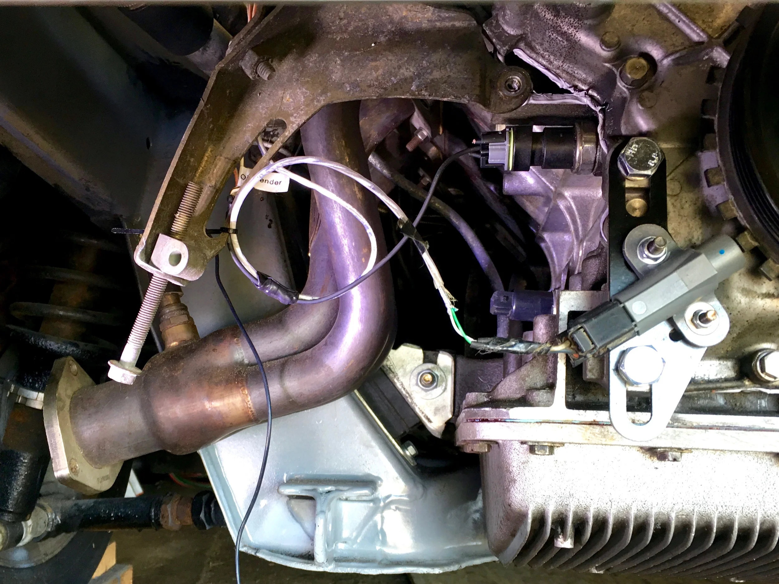 Final wiring of the crank sensor, oil sender (tied into both the gauge and light wires), and the unused knock sensor. Care is taken to ensure that the wires don't come in contact with the intake manifold by zip-tying them to the A/C tensioning arm.