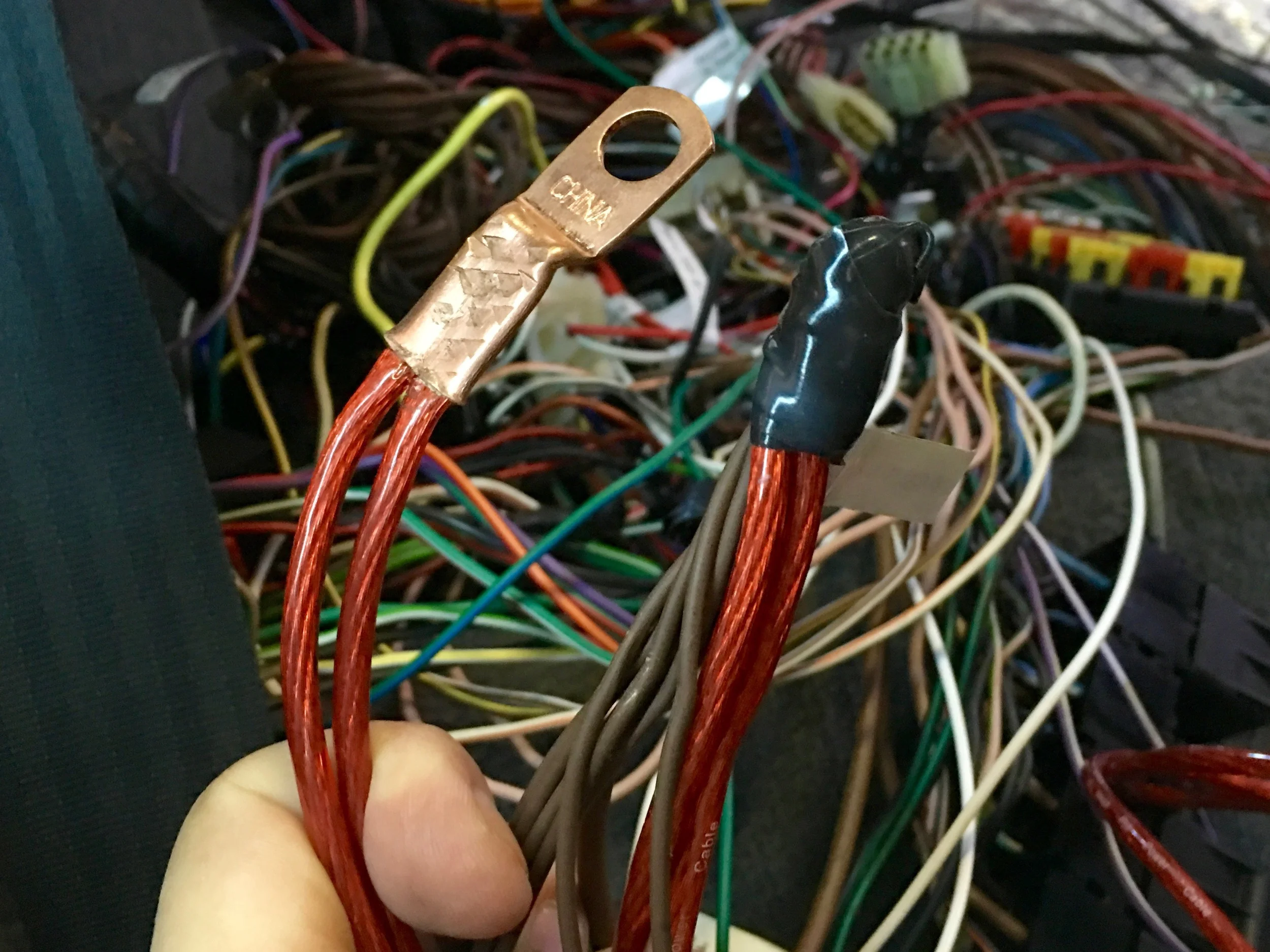 The wire bundle wrapped in self-fusing tape, and the ring terminal for the red wires that will go to the bulkhead battery post.