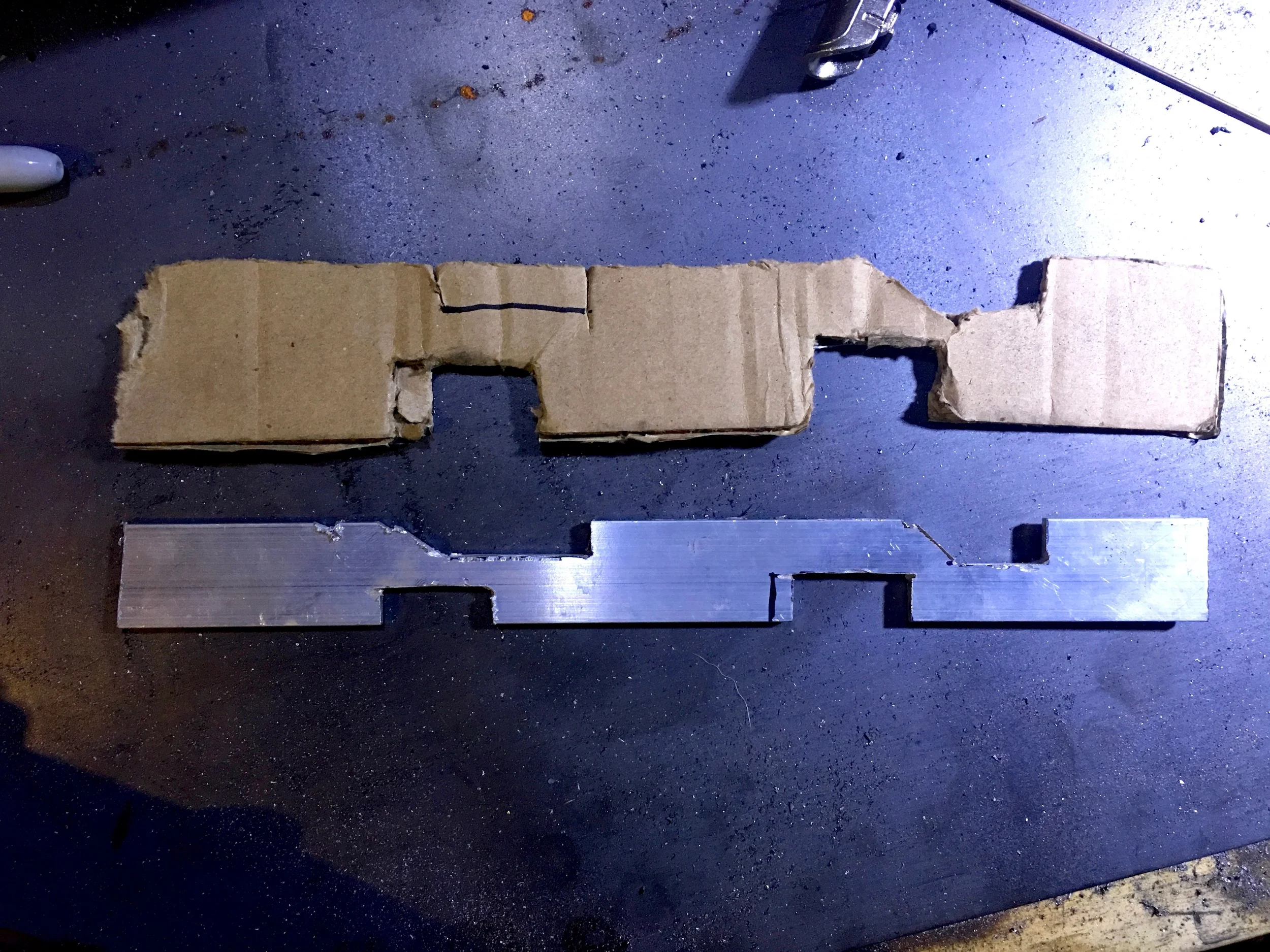 The cardboard template and the not-quite-wide-enough piece of aluminum cut from it.