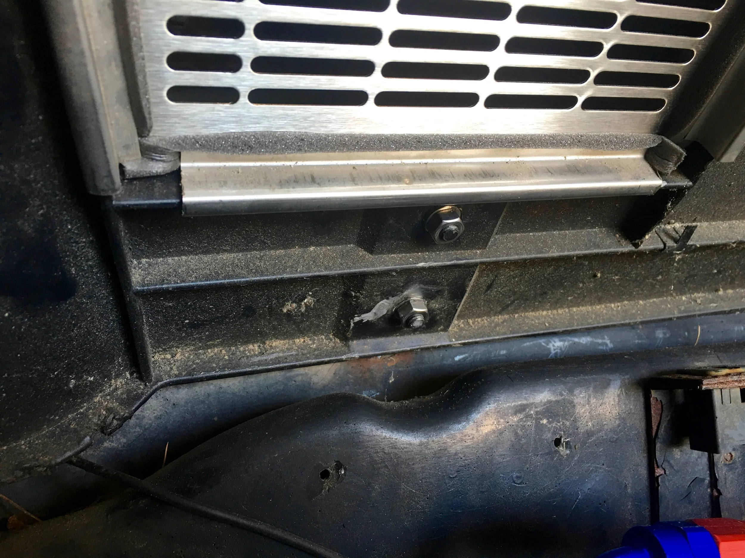 The driver's side engine hinge with new stainless nuts installed.