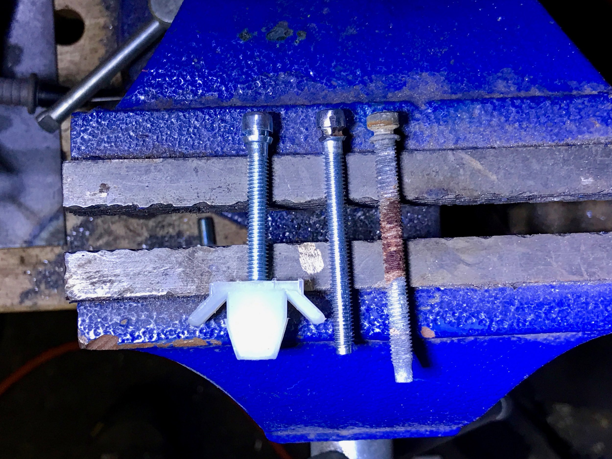 The original headlight screw (right), a new modified headlight screw (center) and the unmodified screw (left).