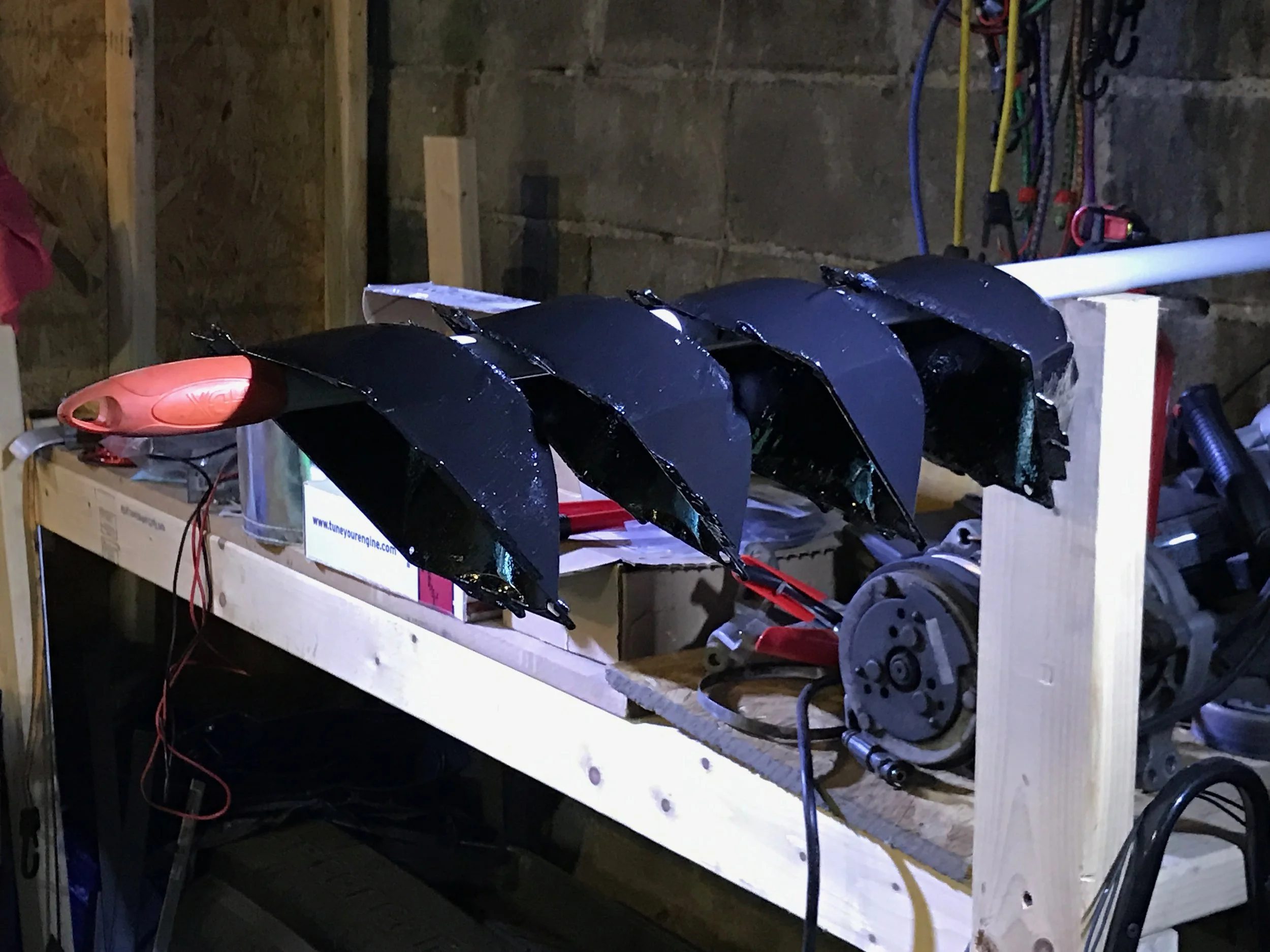 A better way to hold the housings while painting them -- stick them on a broom handle. This allows much better coverage and keeps the POR-15 from sticking to the cardboard I'd originally used.